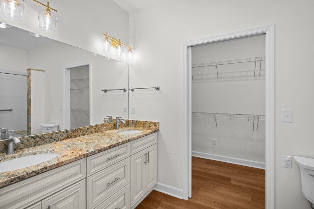 with double sink vanity, granite countertop, lots of storage and walk-in closet!