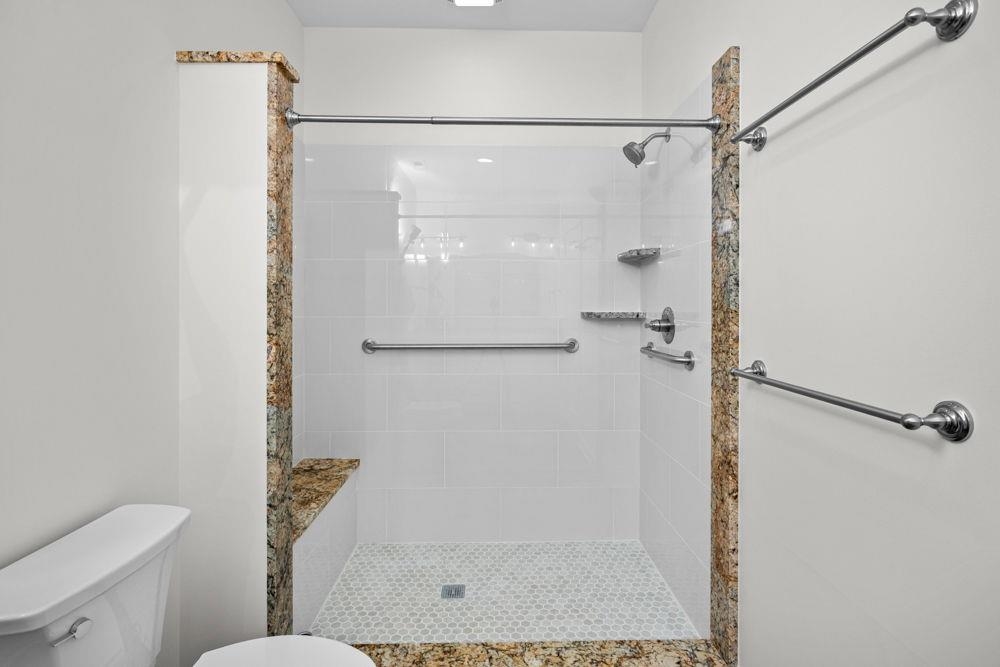 with walk-in shower featuring grab bars & extra towel bar.