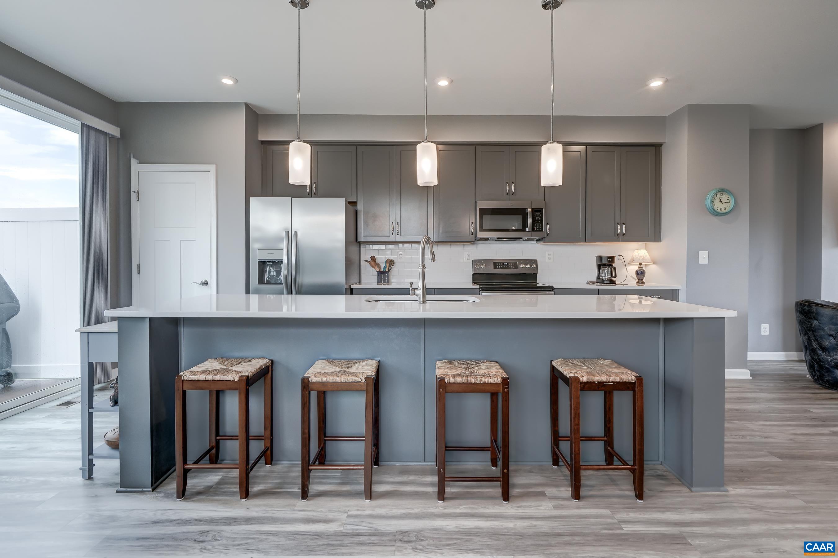 Large island features plenty of seating, and pendant lighting.