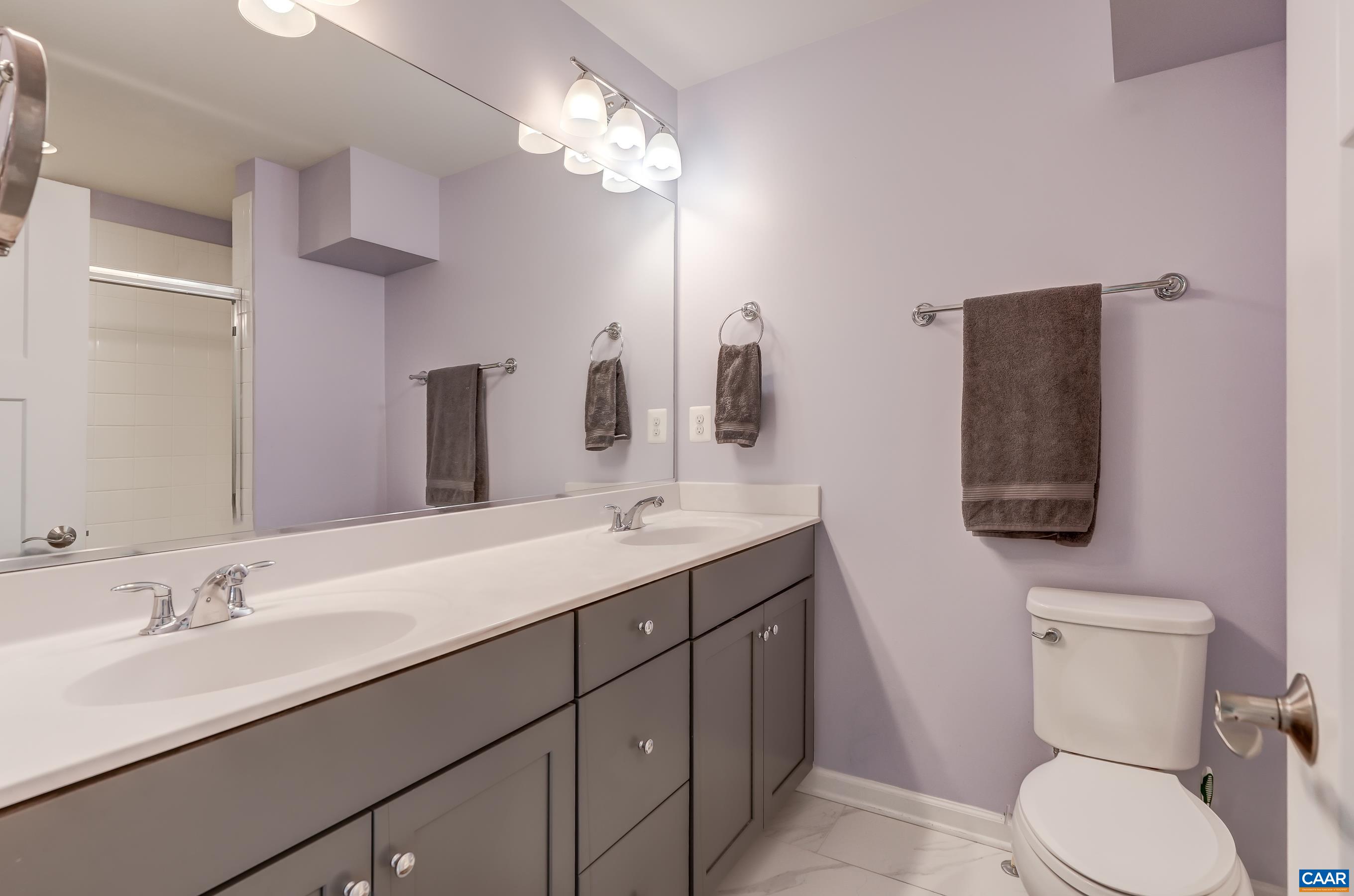 Primary bath with double sink vanity and walk-in shower.