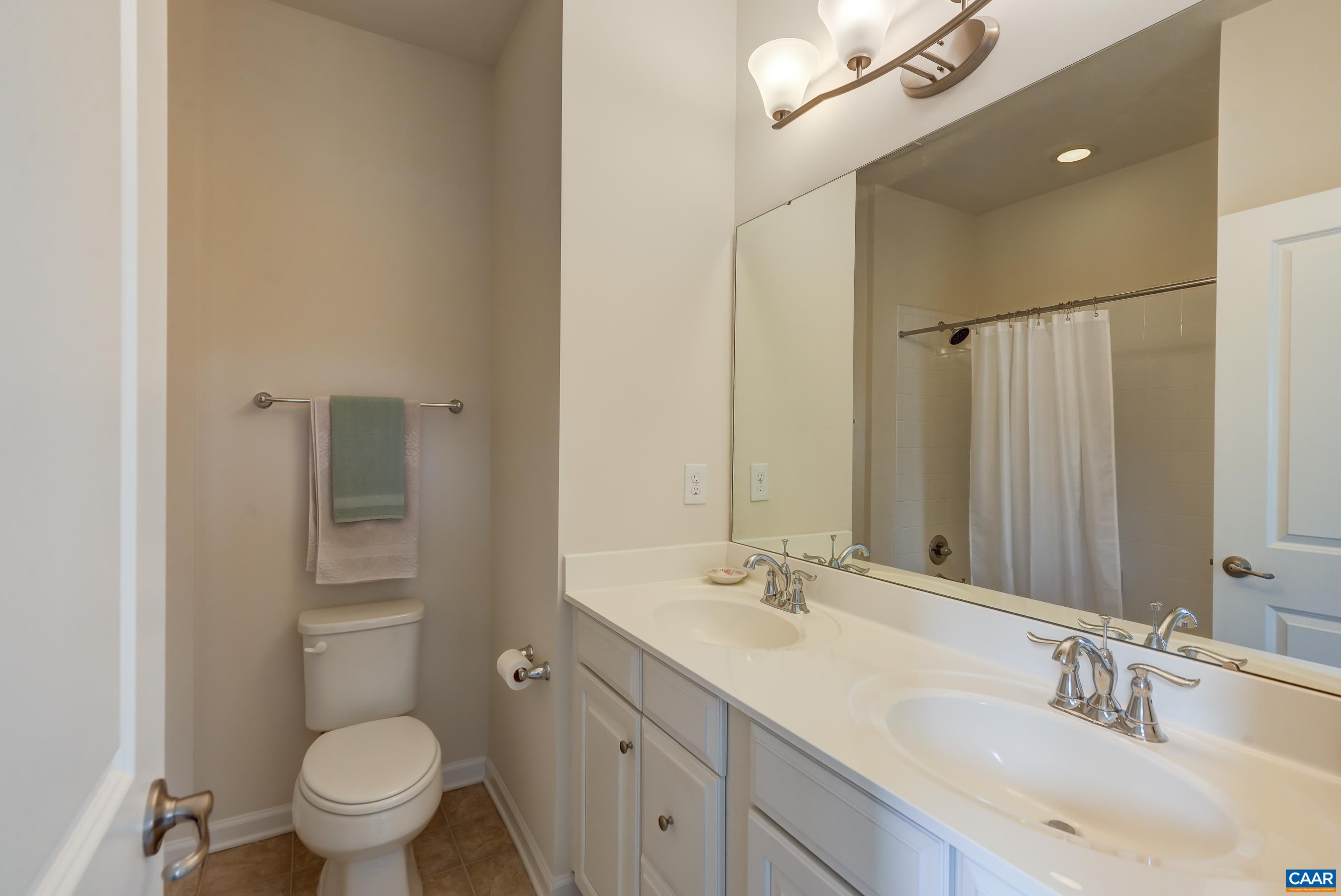 Primary bathroom with double sink vanity and tub/shower combo.