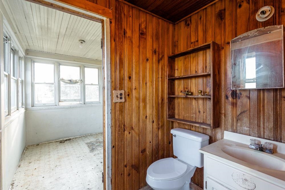 Between the kitchen and enclosed porch.