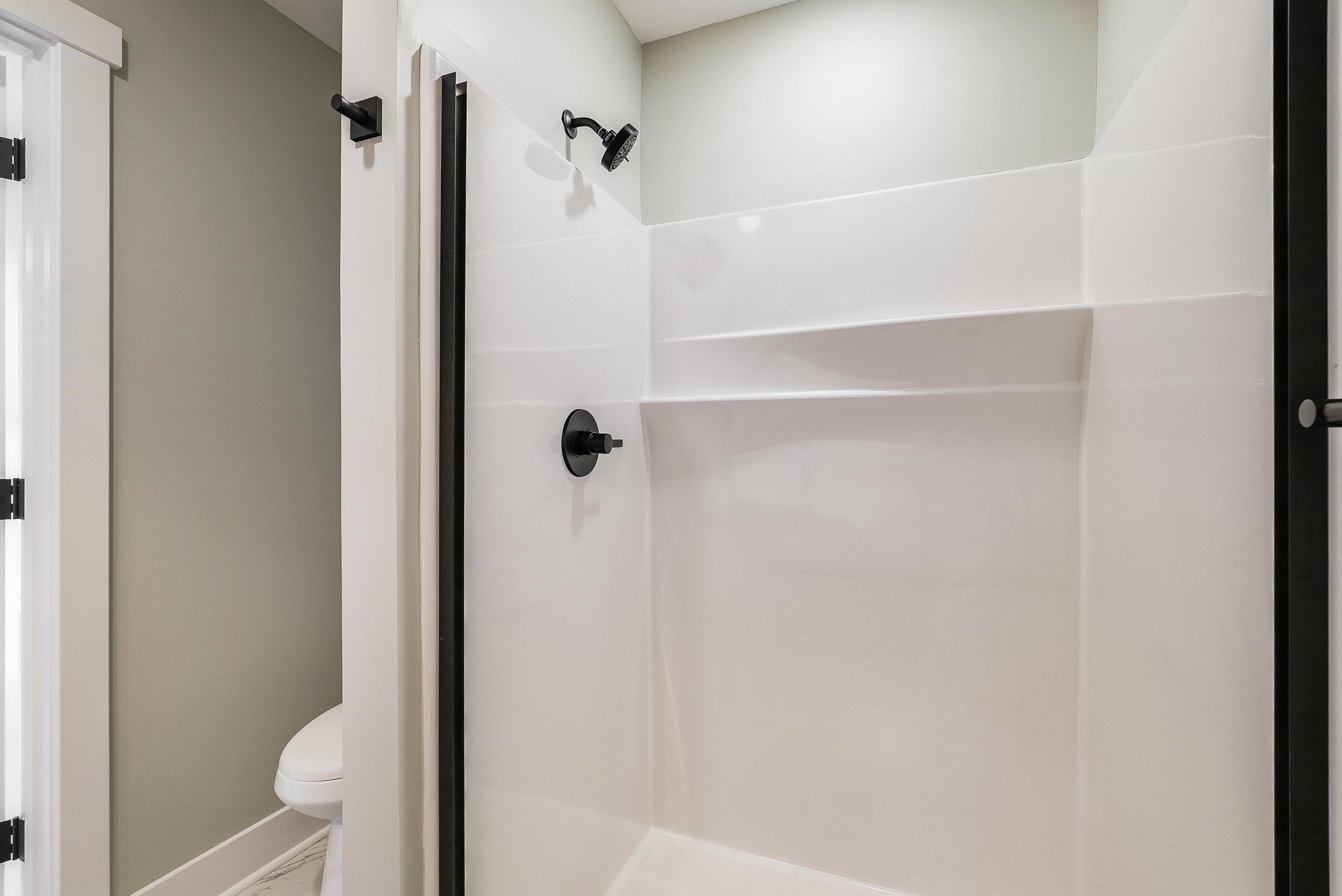 Primary bath of our model home featuring an upgraded quartz countertop, large single vanity and walk in shower with optional glass door upgrade. Primary bath of our model home featuring an upgraded quartz countertop, large single vanity and walk in shower with optional glass door upgrade.