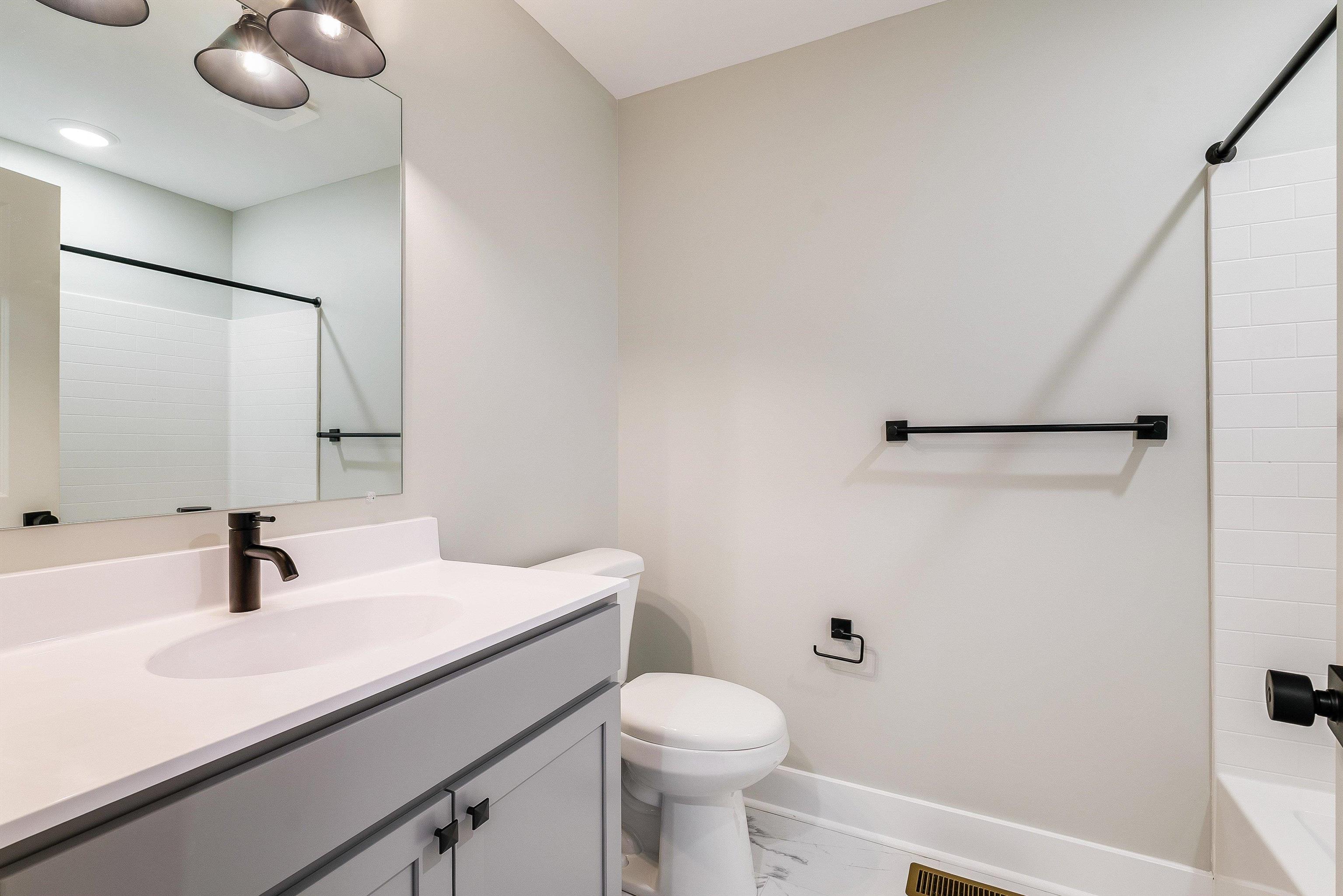 2nd full bath upstairs in the hallway features a large single vanity, tub/shower combo, and black plumbing fixtures. 2nd full bath upstairs in the hallway features a large single vanity, tub/shower combo, and black plumbing fixtures.