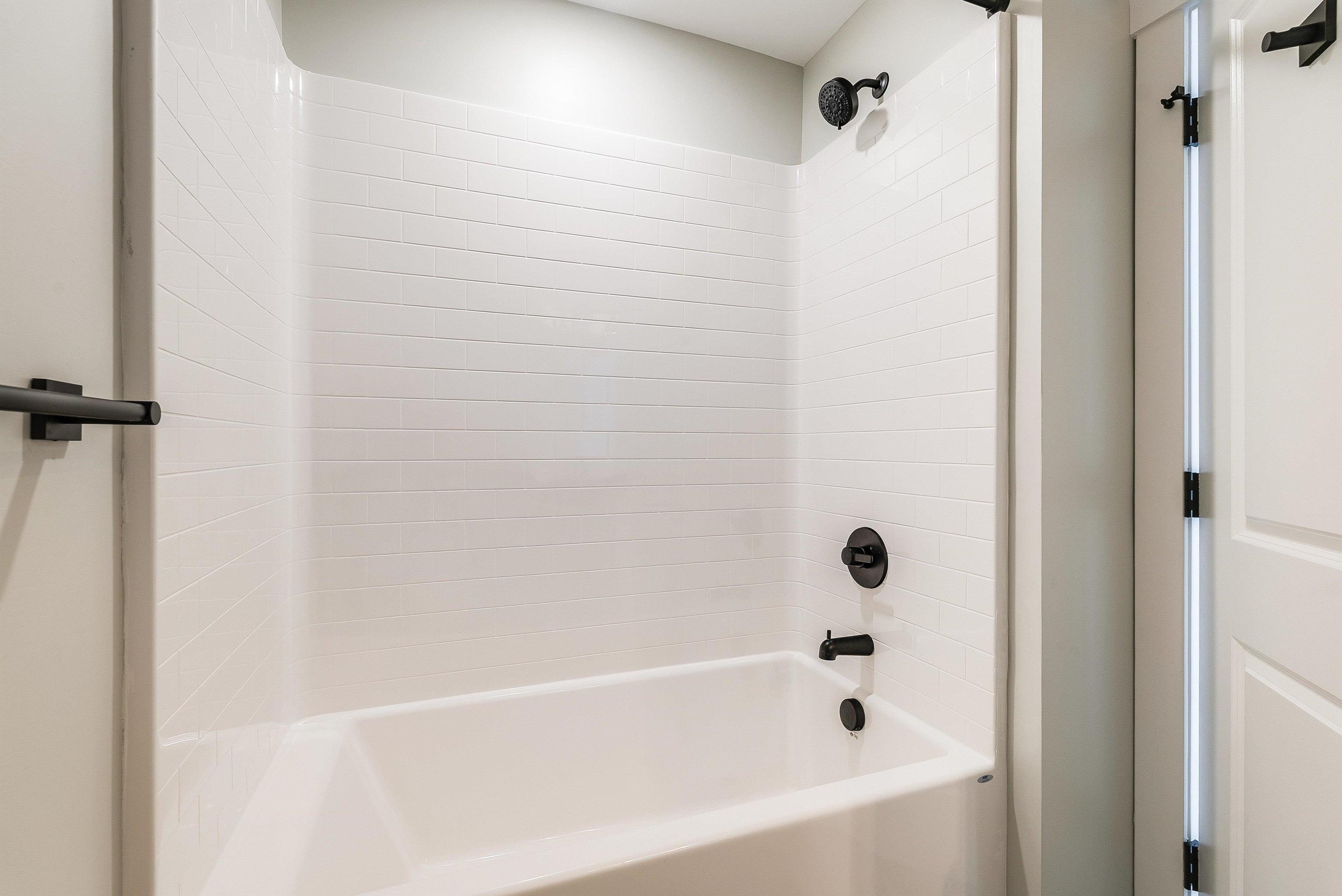 2nd full bath upstairs in the hallway features a large single vanity, tub/shower combo, and black plumbing fixtures. 2nd full bath upstairs in the hallway features a large single vanity, tub/shower combo, and black plumbing fixtures.