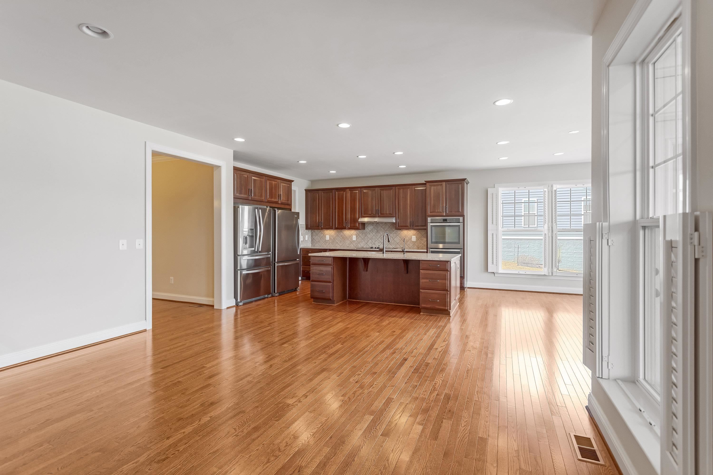 This open concept kitchen features many upgrades throughout.  A few include stainless steel appliances, two refrigerators, recessed lighting, granite counter-tops, hardwood flooring, breakfast bar, and plenty of space for an additional dining space.
