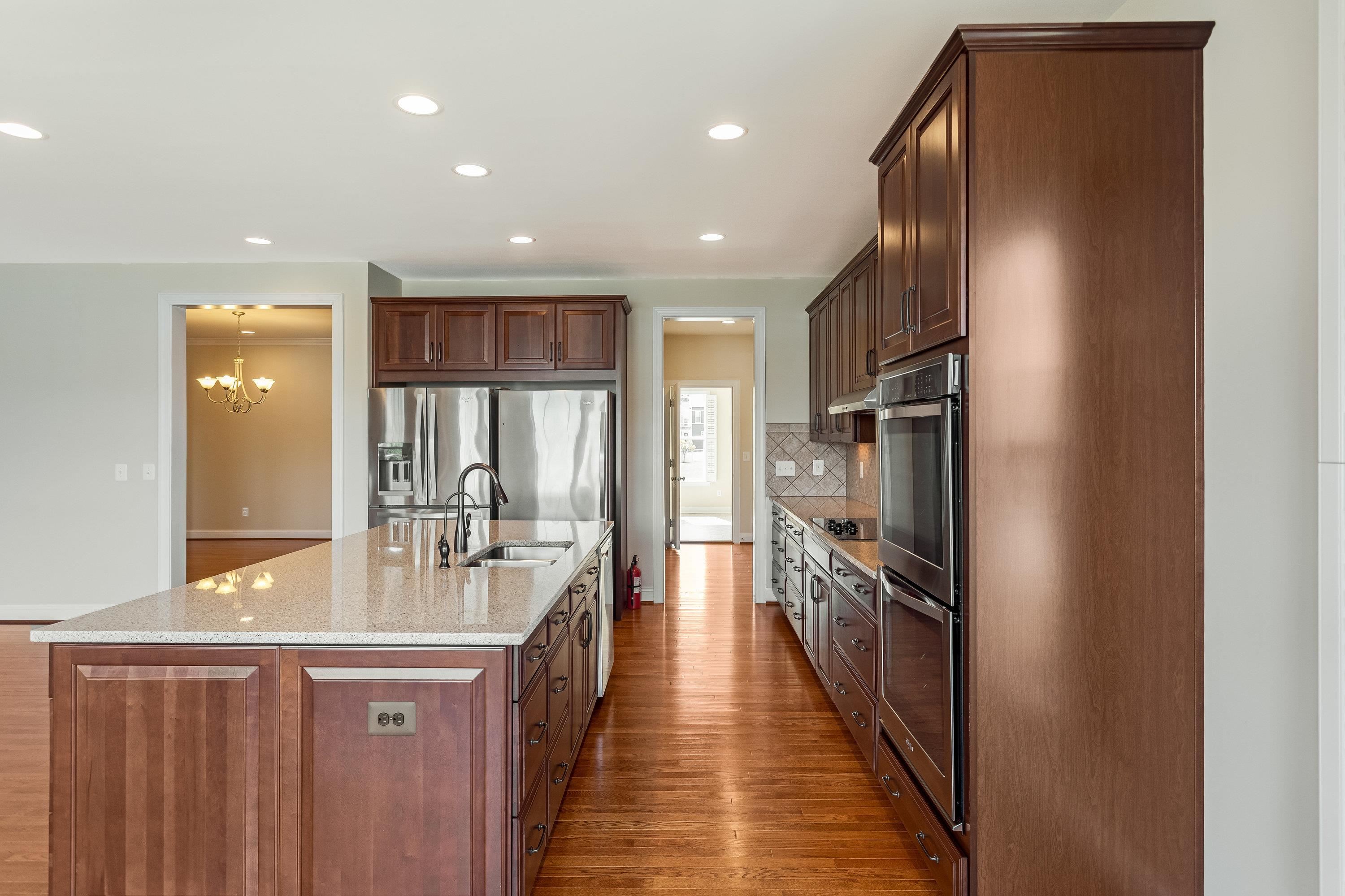 This open concept kitchen features many upgrades throughout.  A few include stainless steel appliances, two refrigerators, recessed lighting, granite counter-tops, hardwood flooring, breakfast bar, and plenty of space for an additional dining space.