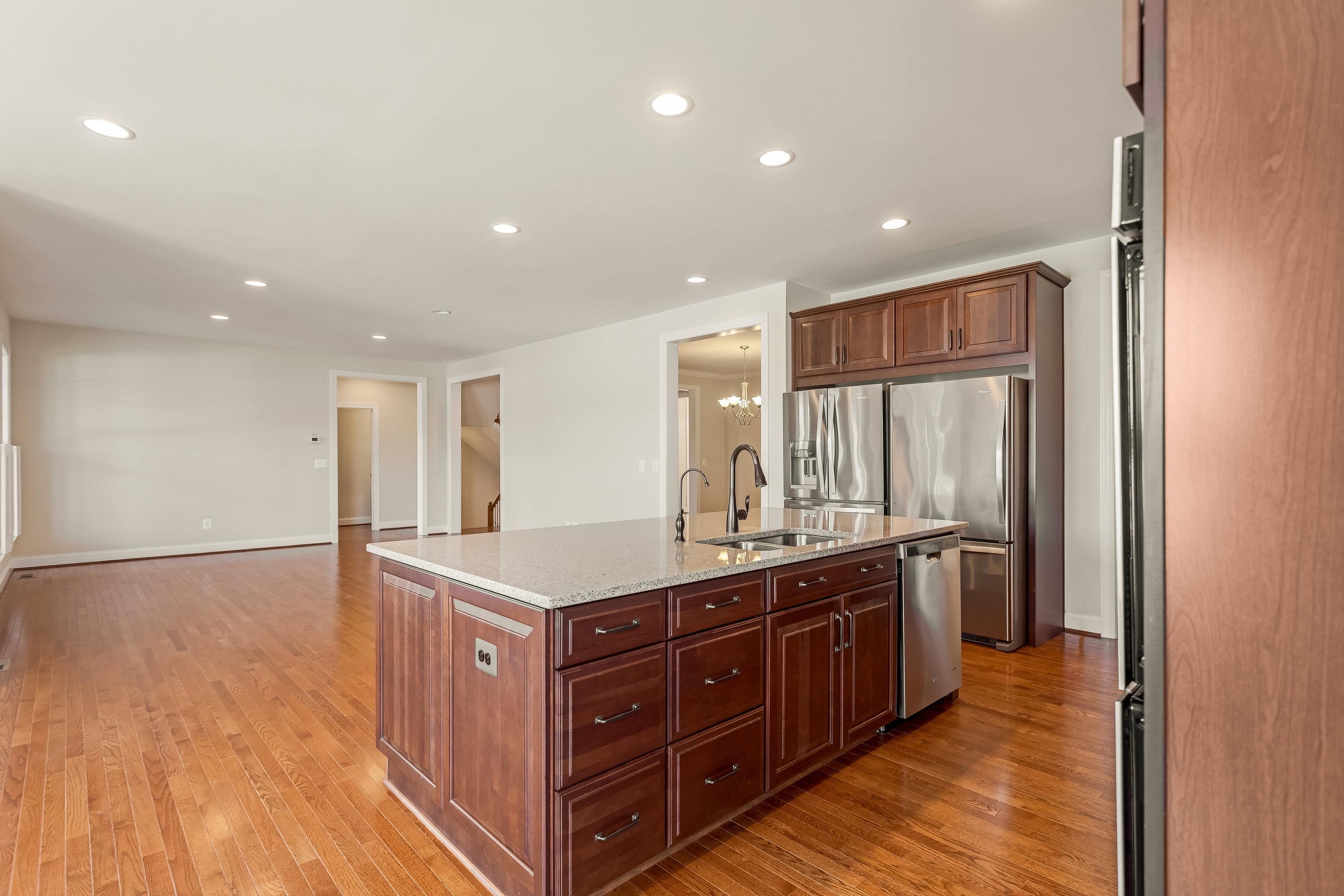 This open concept kitchen features many upgrades throughout.  A few include stainless steel appliances, two refrigerators, recessed lighting, granite counter-tops, hardwood flooring, breakfast bar, and plenty of space for an additional dining space.