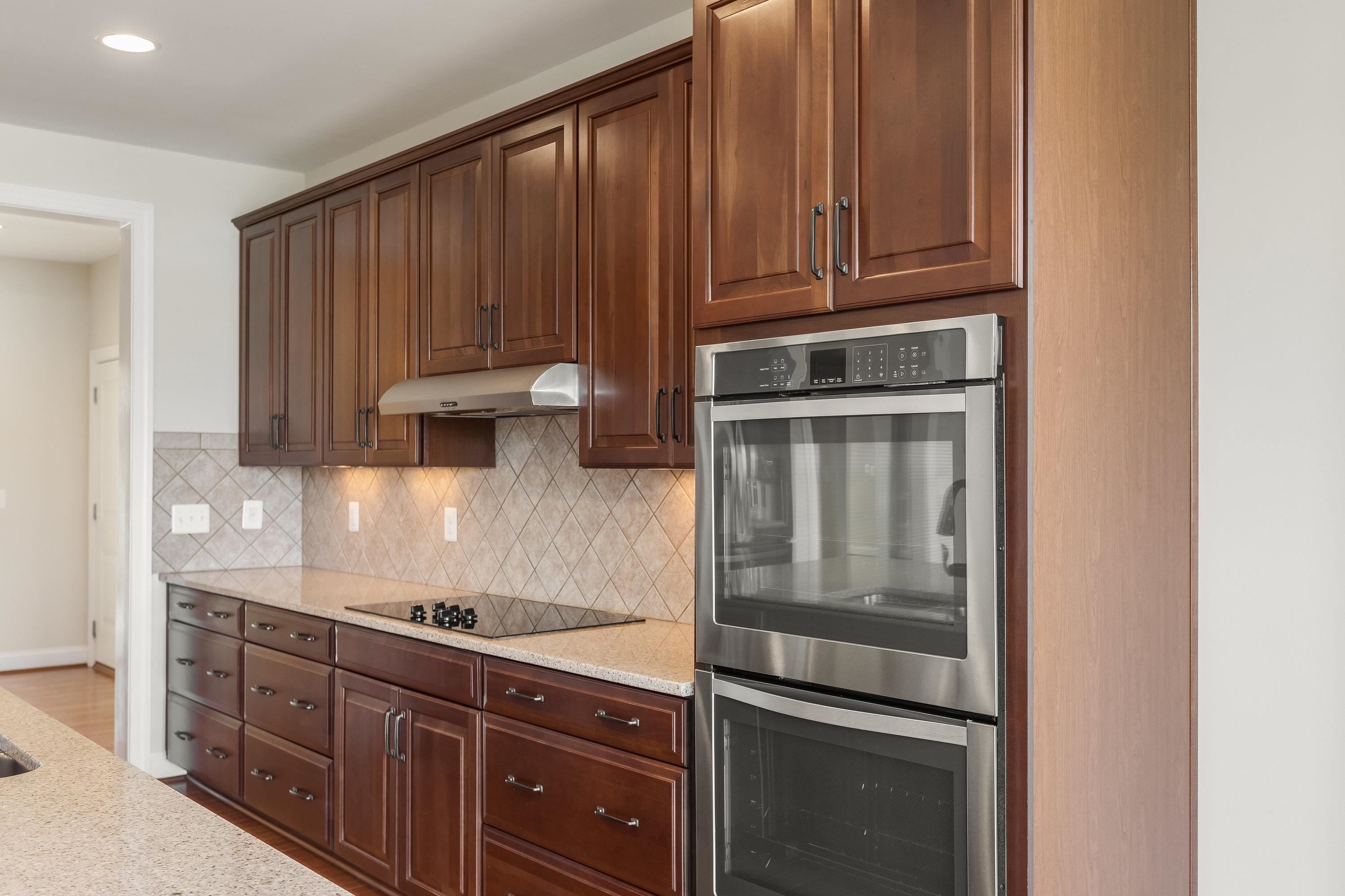 This open concept kitchen features many upgrades throughout.  A few include stainless steel appliances, two refrigerators, recessed lighting, granite counter-tops, hardwood flooring, breakfast bar, and plenty of space for an additional dining space.