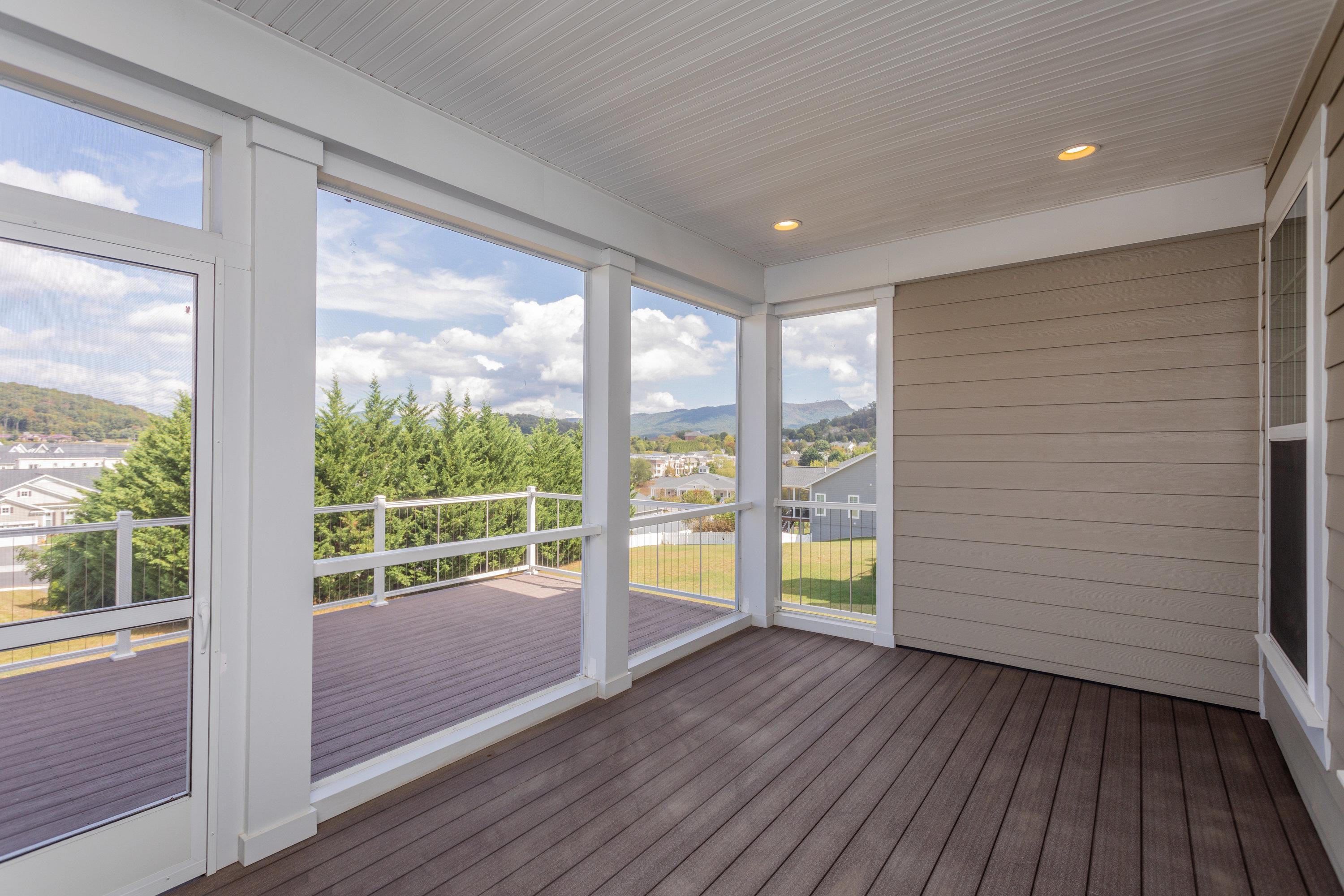The screened-in porch space is a lovely area with beautiful views, recessed lighting, composite flooring, and more!