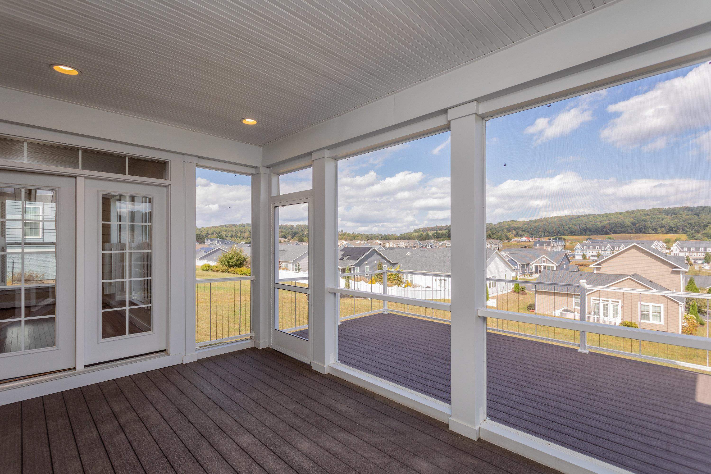 The screened-in porch space is a lovely area with beautiful views, recessed lighting, composite flooring, and more!