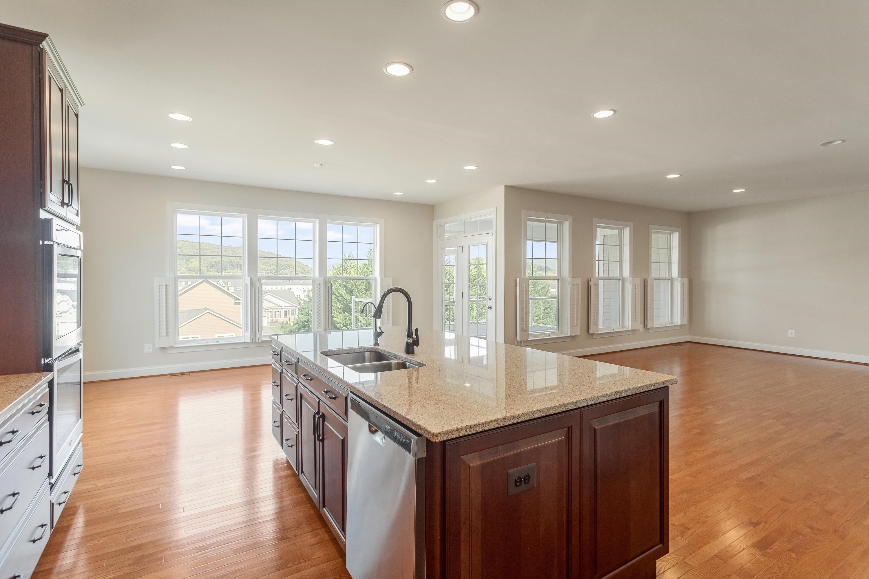 This open concept kitchen features many upgrades throughout.  A few include stainless steel appliances, two refrigerators, recessed lighting, granite counter-tops, hardwood flooring, breakfast bar, and plenty of space for an additional dining space.