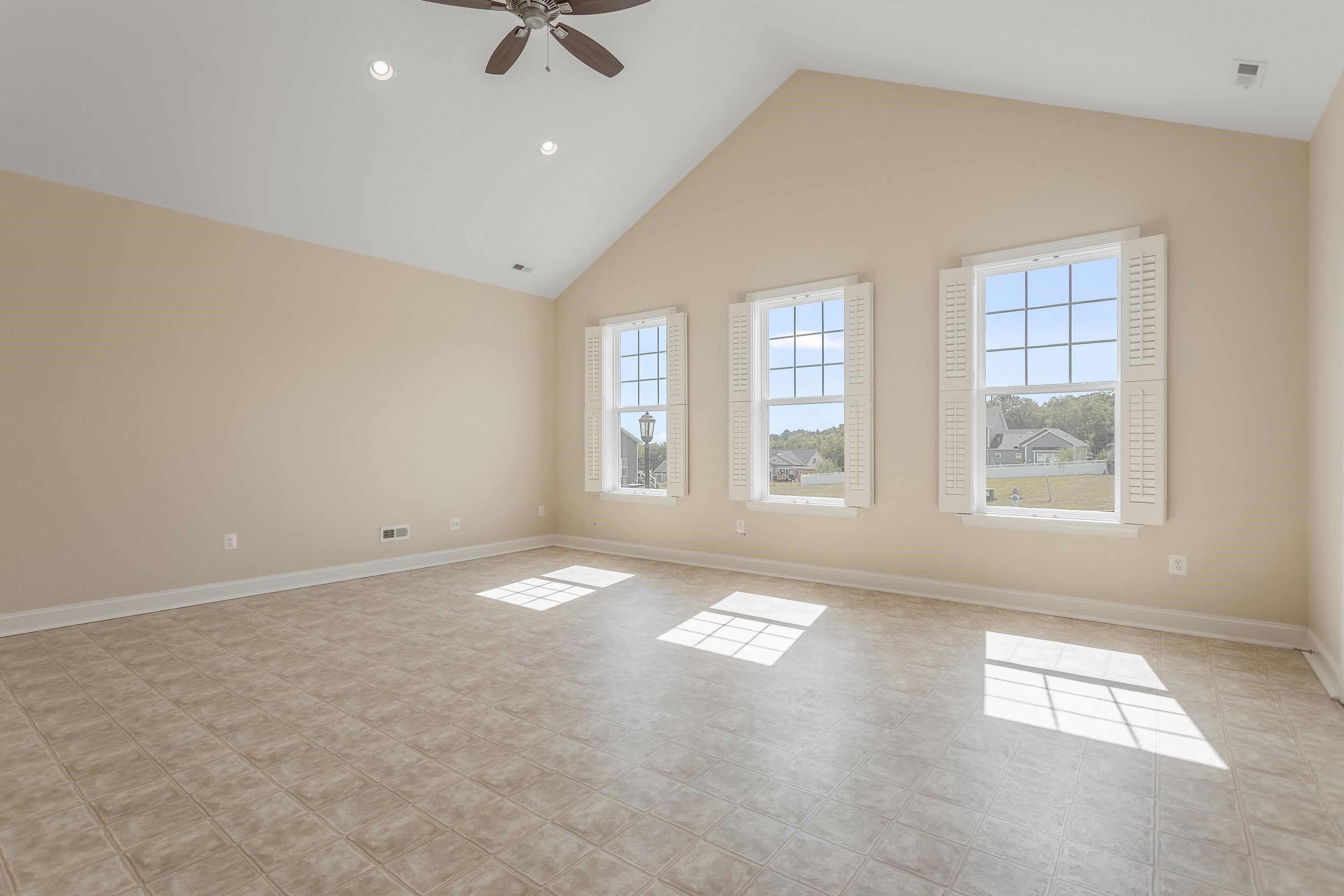 This very large space offers elevated ceilings, large windows, vinyl flooring, ceiling fan, and an abundance of space for use as an additional living room, exercise space, playroom, etc.