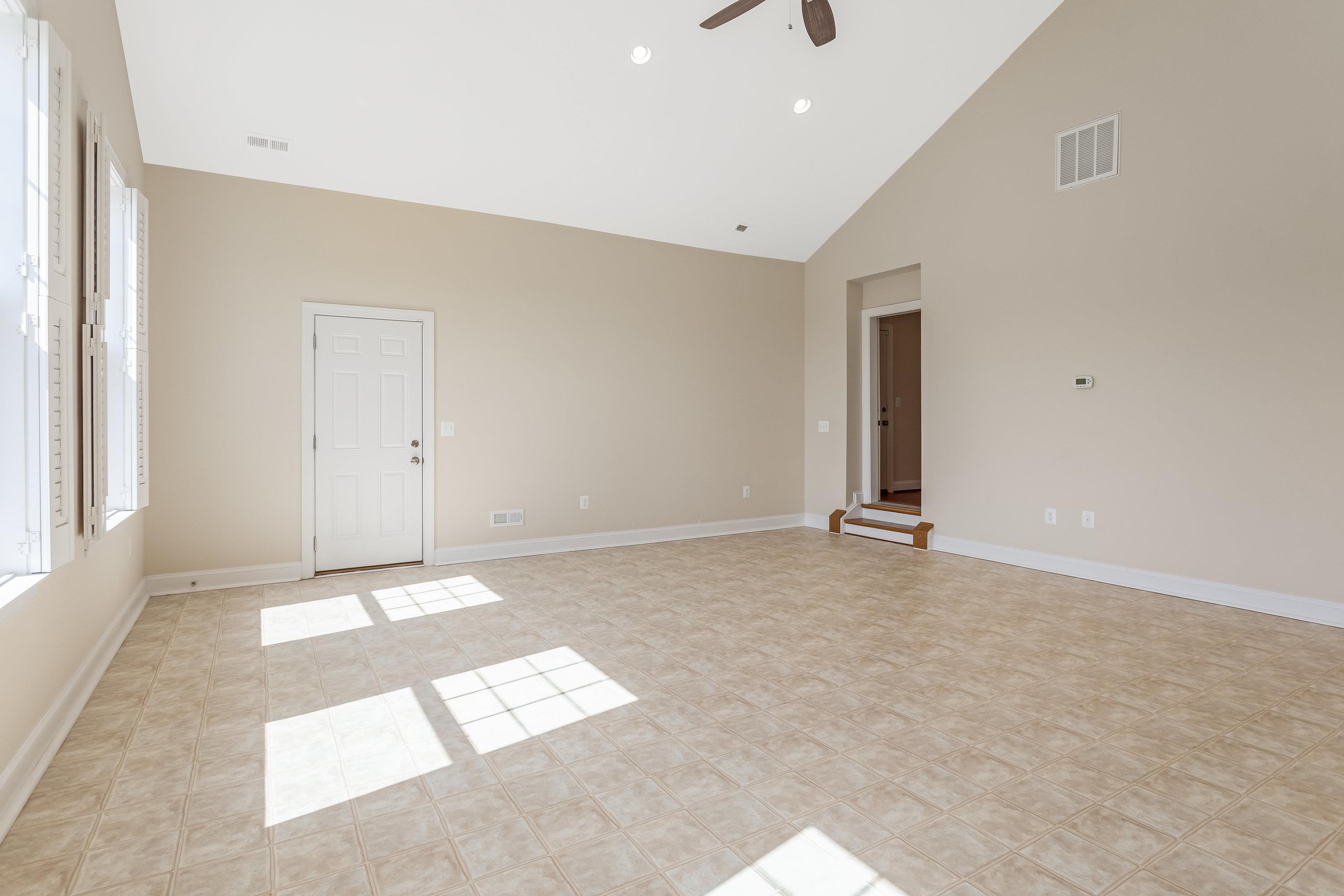 This very large space offers elevated ceilings, large windows, vinyl flooring, ceiling fan, and an abundance of space for use as an additional living room, exercise space, playroom, etc.