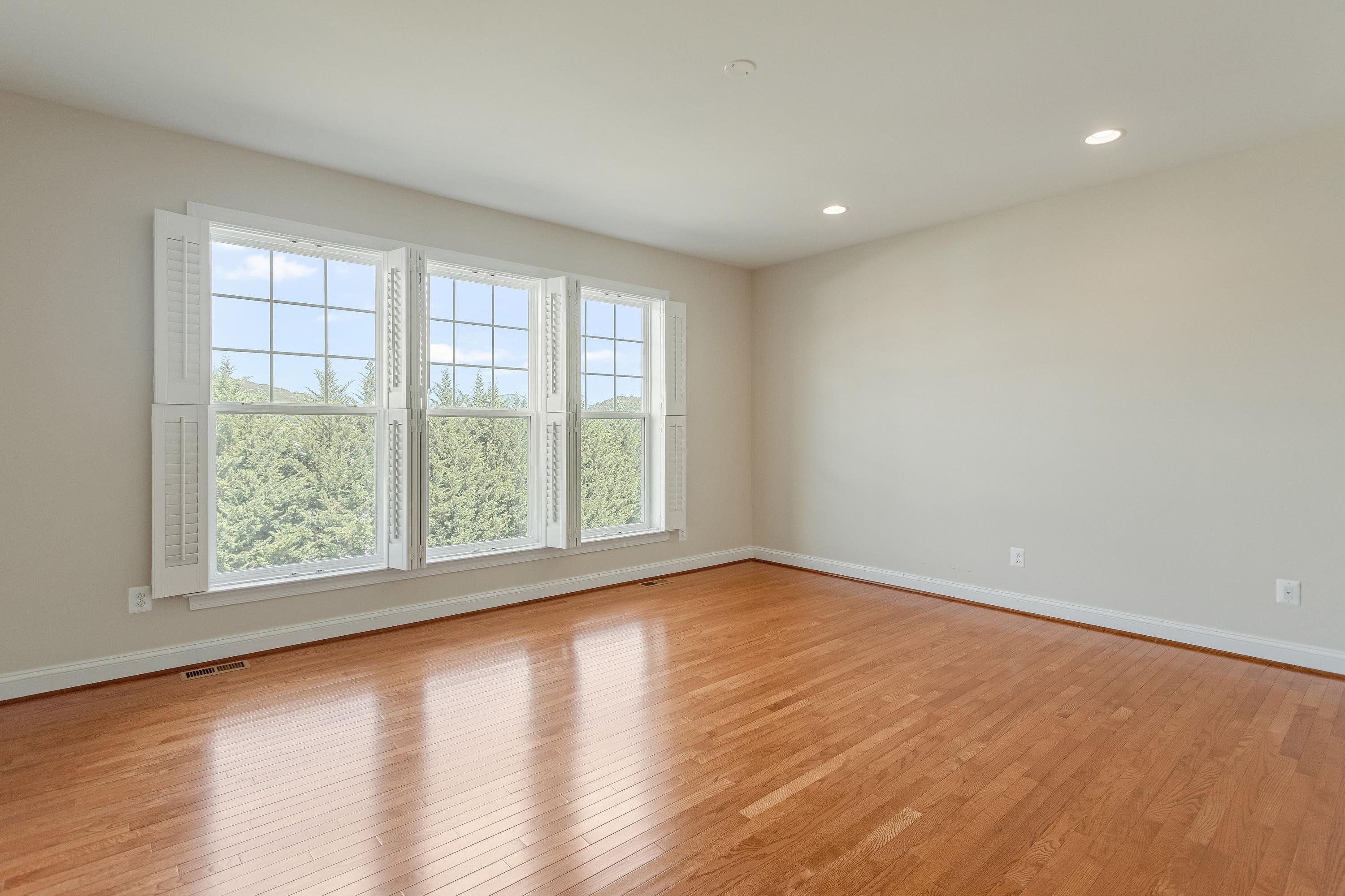 The very large primary bedroom offers hardwood flooring throughout, large windows, recessed lighting, spacious walk-in closet, and full attached bathroom.