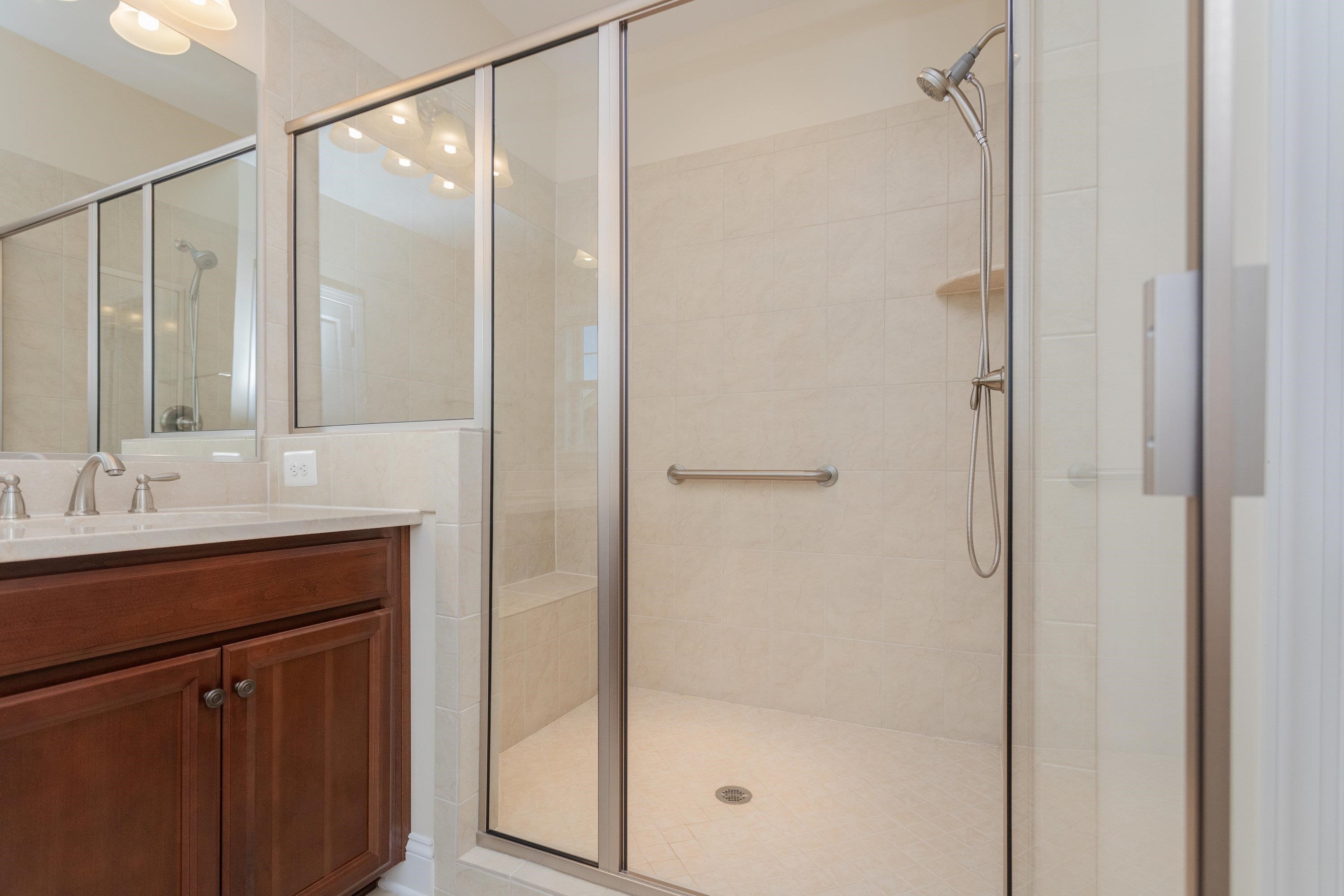 The primary bathroom offers tile flooring and dual vanities.  This bathroom features a whirlpool bathtub and seperate toilet/pedastal sink space.