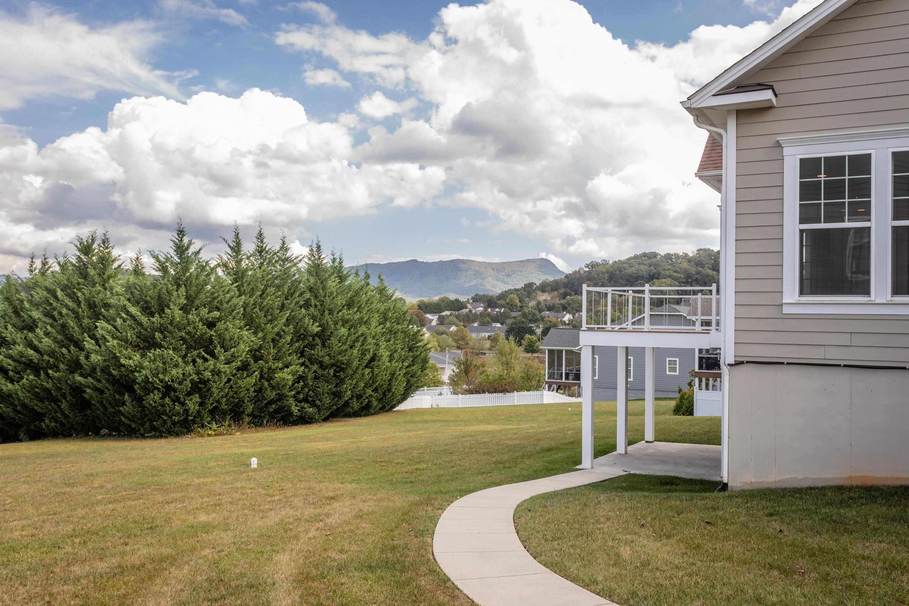 The rear view of the home highlights the spacious lot, screened-in porch, deck, covered patio, and much more!