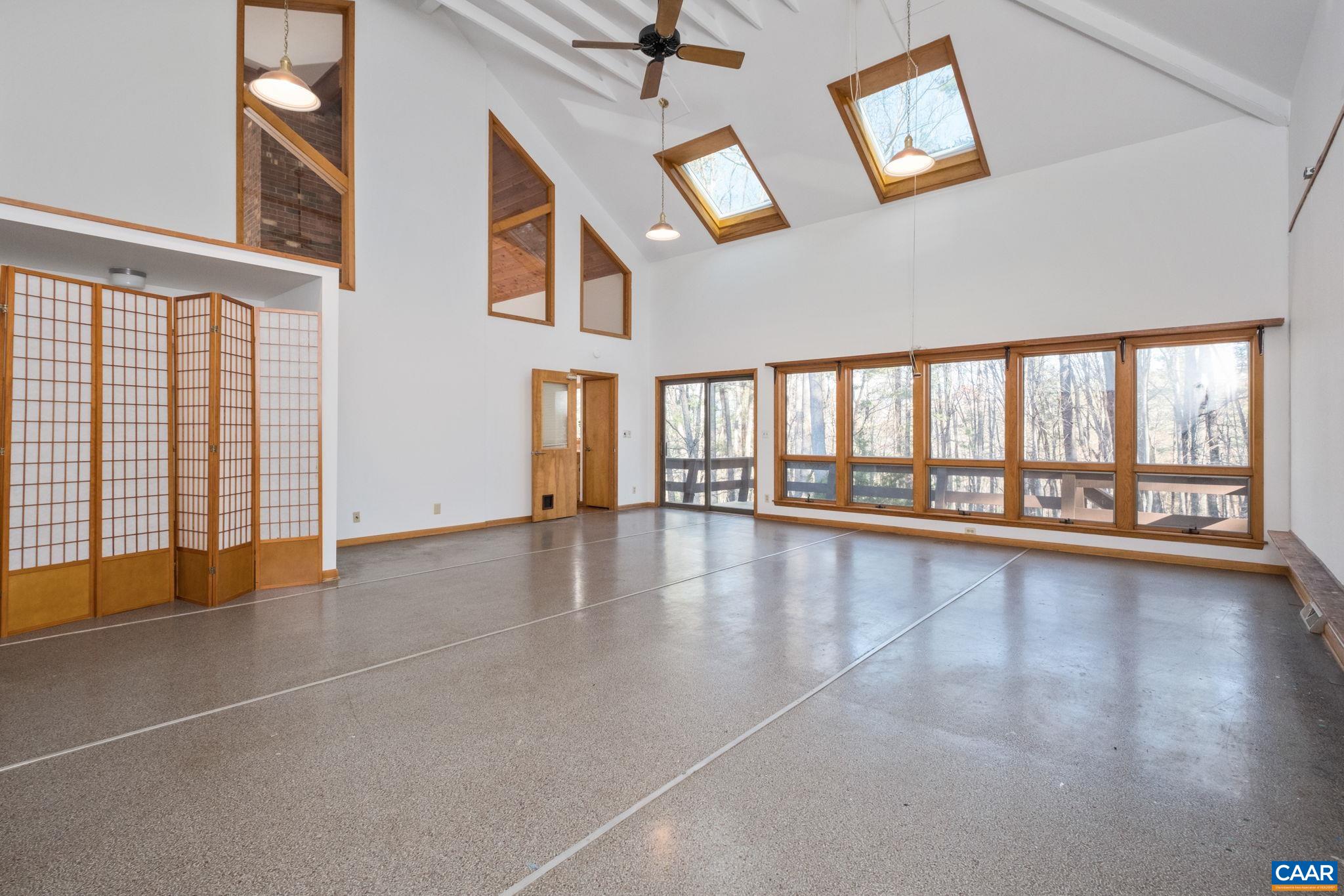the directional position, wall of oversize glass windows facing the woods, the oversized remote-opening solar-powered skylights, soaring ceiling height, well positioned outlets were all carefully designed for a professional art studio.