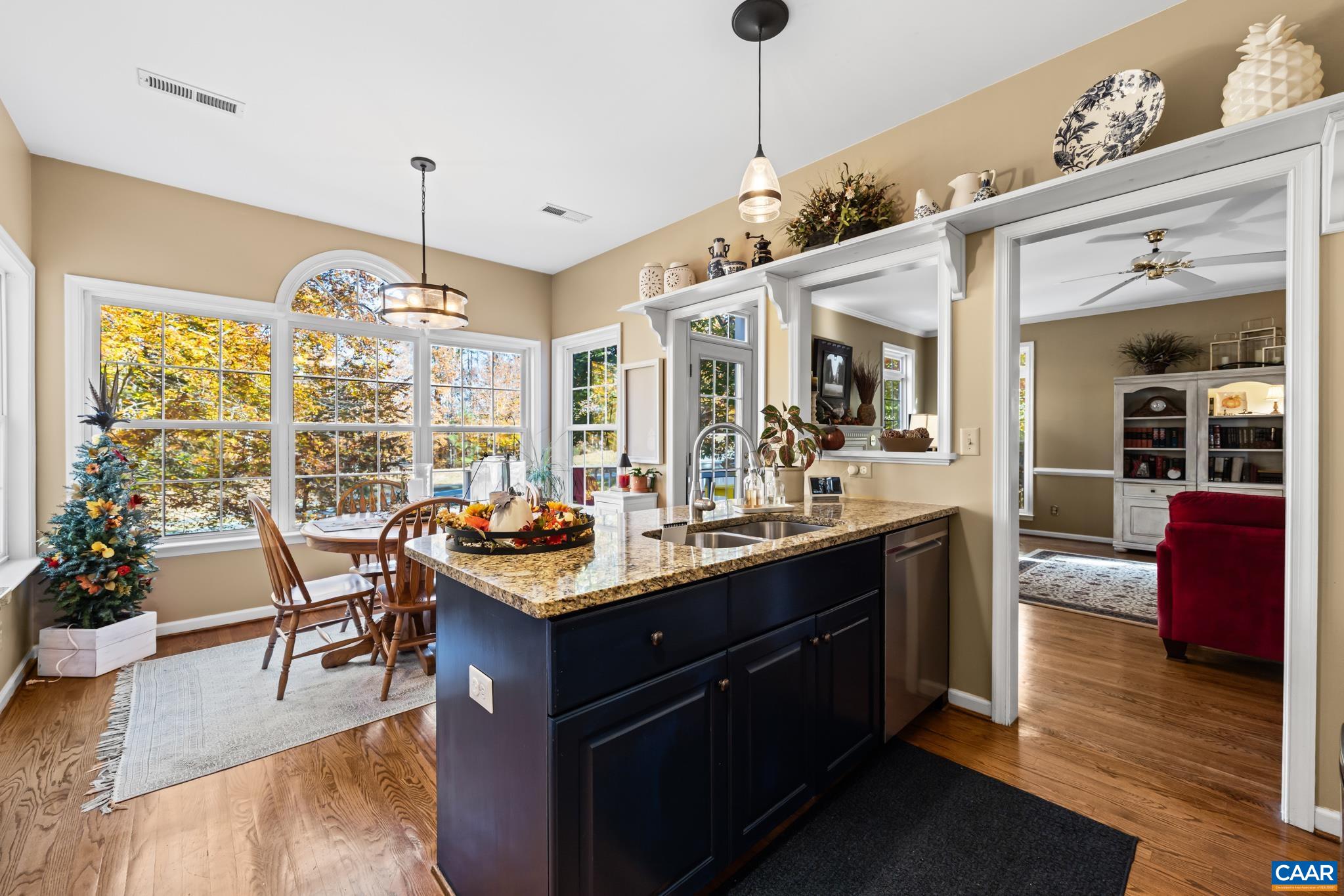 This bright kitchen features a large island with a granite countertop and double sink, perfect for meal prep, serving, clean up. Adjacent dining nook, large windows, stunning wooded views, ample natural light. Enjoy the seamless flow into living room. This bright kitchen features a large island with a granite countertop and double sink, perfect for meal prep, serving, clean up. Adjacent dining nook, large windows, stunning wooded views, ample natural light. Enjoy the seamless flow into living room.