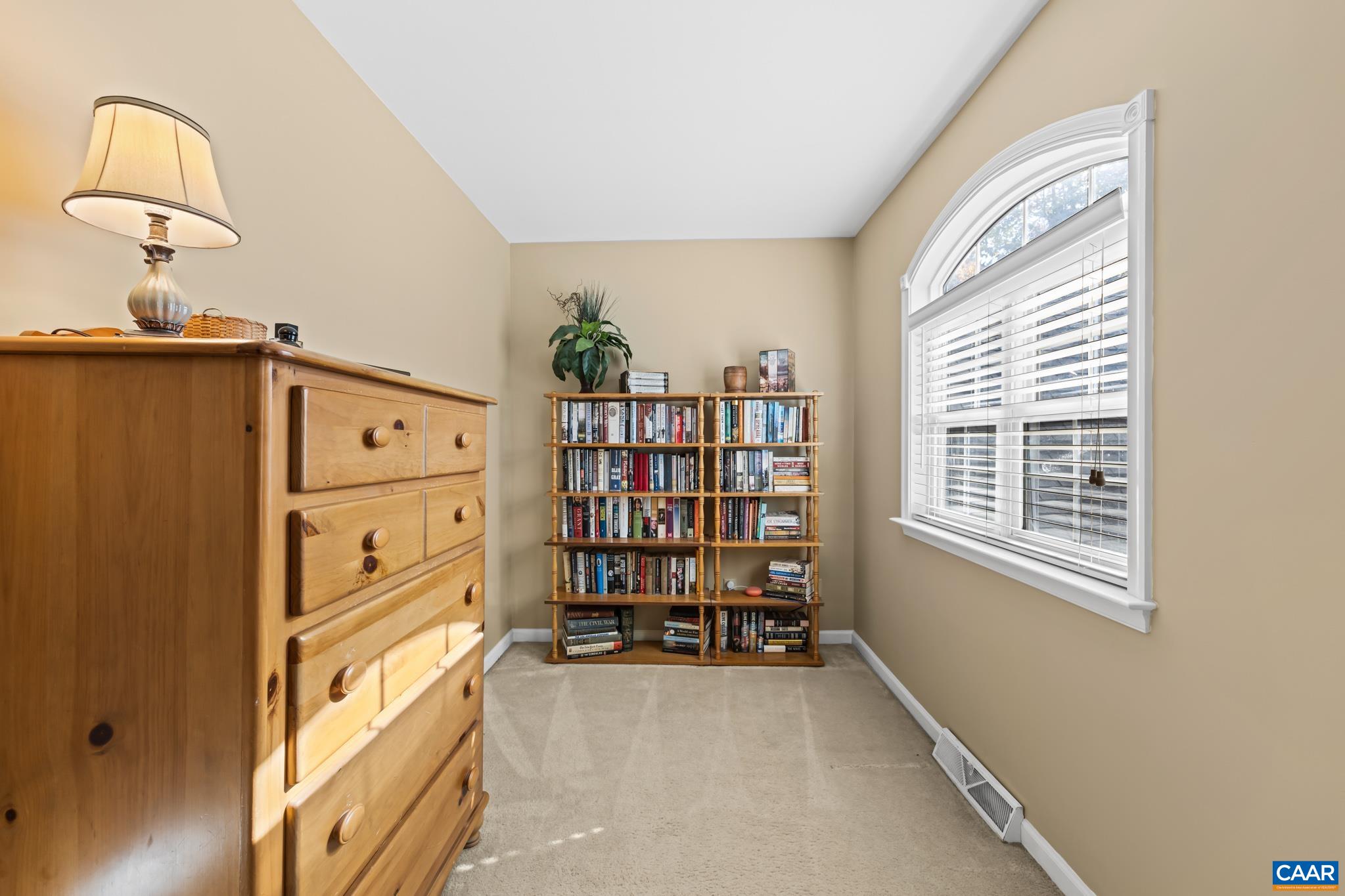 This primary suite reading nook with warm neutral walls, plush carpet, and great natural light from an arched window is a very functional flex space. This primary suite reading nook with warm neutral walls, plush carpet, and great natural light from an arched window is a very functional flex space.