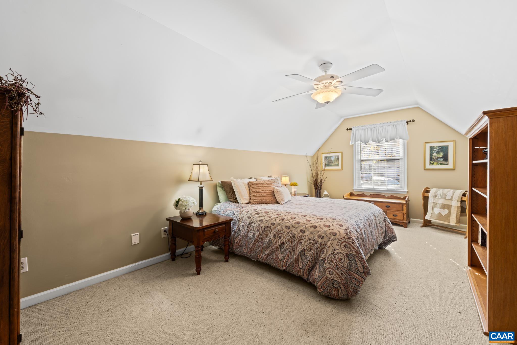 Discover a cozy retreat in this bonus room or bedroom. It features a sloped ceiling, plush carpet, and natural light from the window, all complemented by warm, neutral walls. Discover a cozy retreat in this bonus room or bedroom. It features a sloped ceiling, plush carpet, and natural light from the window, all complemented by warm, neutral walls.