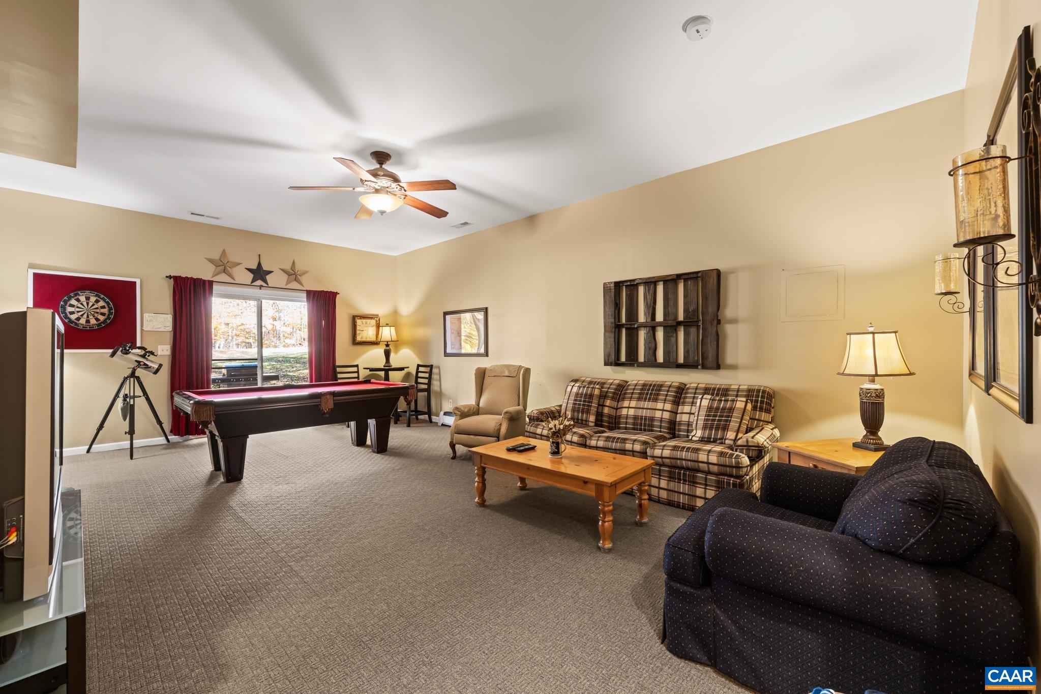 Descend into the finished basement on a plush, carpeted staircase. This lower level offers a bright hallway leading to a versatile bonus room with warm carpet, a cozy sitting area, and ample space for relaxation or recreation. Descend into the finished basement on a plush, carpeted staircase. This lower level offers a bright hallway leading to a versatile bonus room with warm carpet, a cozy sitting area, and ample space for relaxation or recreation.