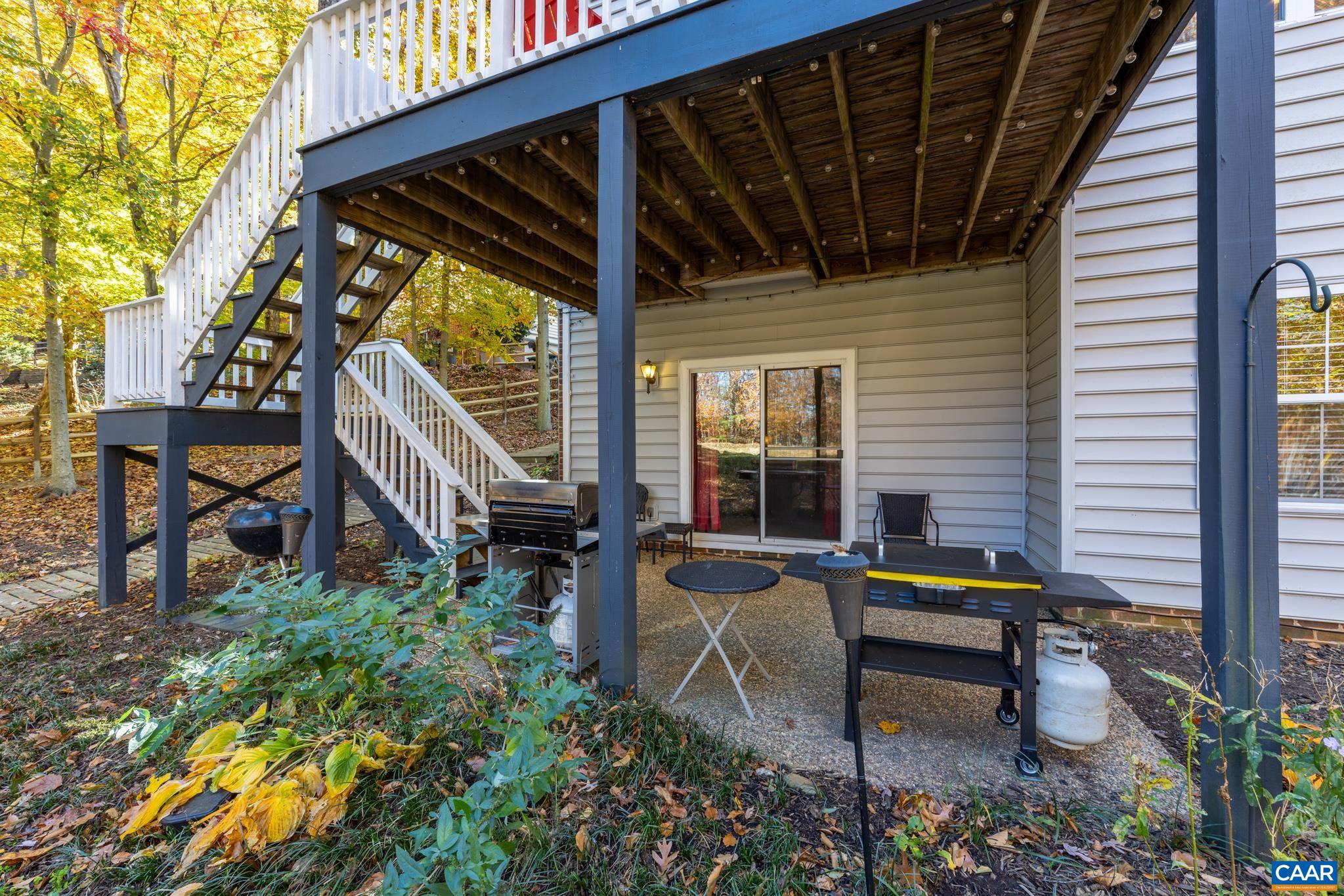 Enjoy a covered patio area perfect for grilling and outdoor dining, featuring a convenient sliding glass door for easy access. Relax in this secluded spot beneath the upper deck, surrounded by the natural beauty of the wooded yard. Enjoy a covered patio area perfect for grilling and outdoor dining, featuring a convenient sliding glass door for easy access. Relax in this secluded spot beneath the upper deck, surrounded by the natural beauty of the wooded yard.