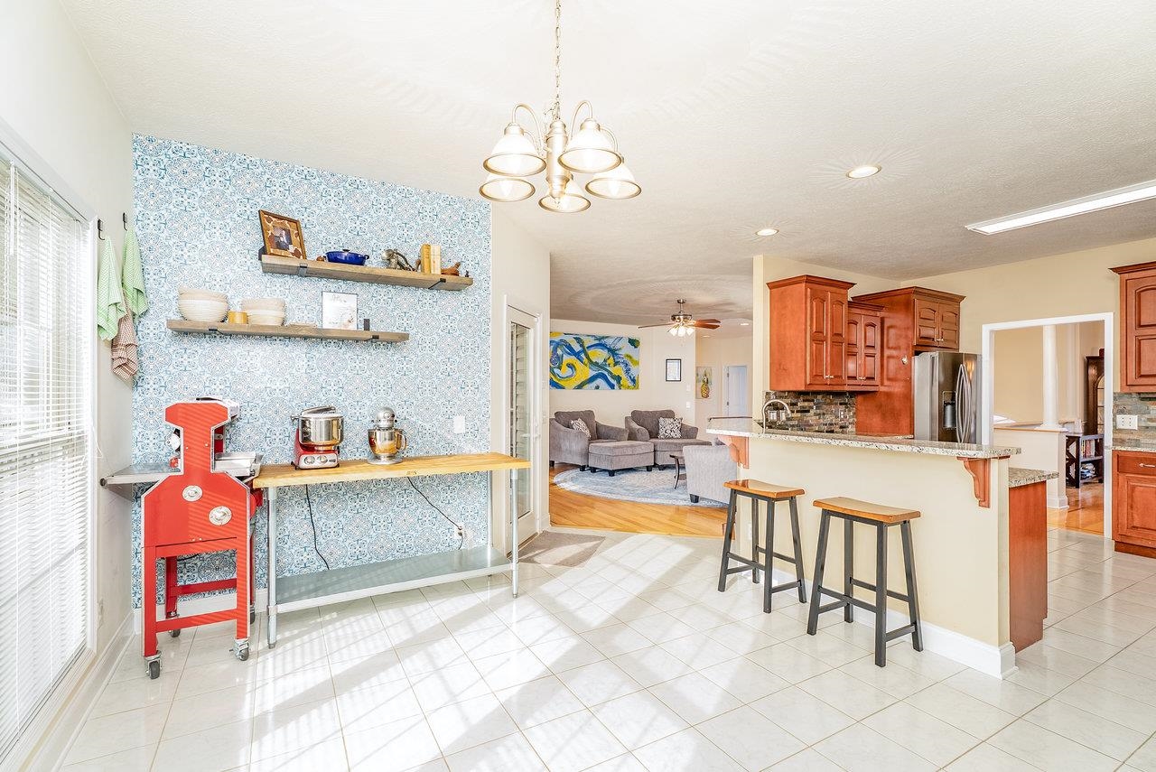 Features: Tile floors, abundant windows that flood the space with natural light, and an open layout flowing into the living room.