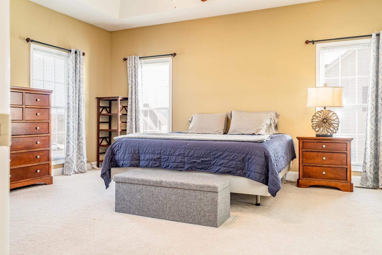 Features: Cozy carpeted floors, a spacious walk-in closet, ceiling fan, generously sized bedroom, and a private ensuite bathroom.