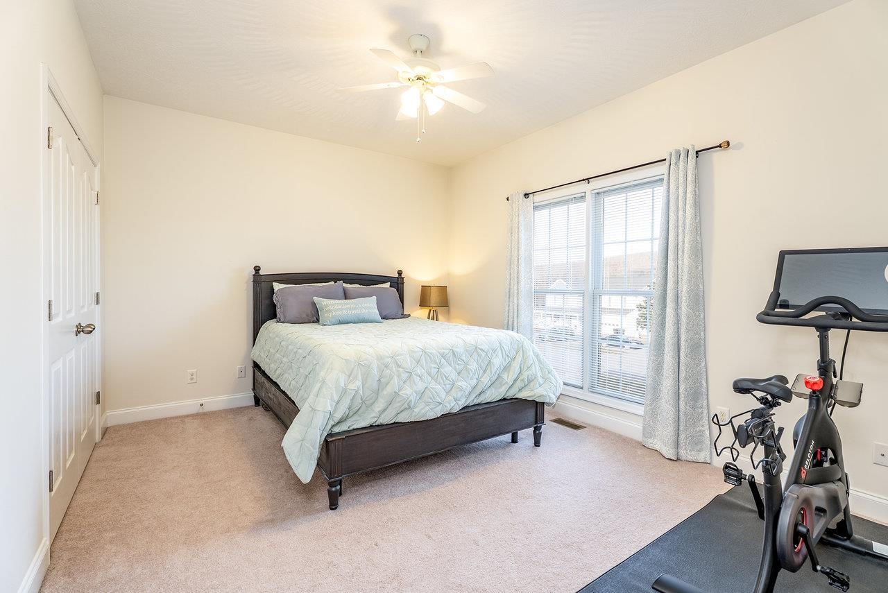 Features: Cozy carpeted floors, a ceiling fan, and a generously sized closet.