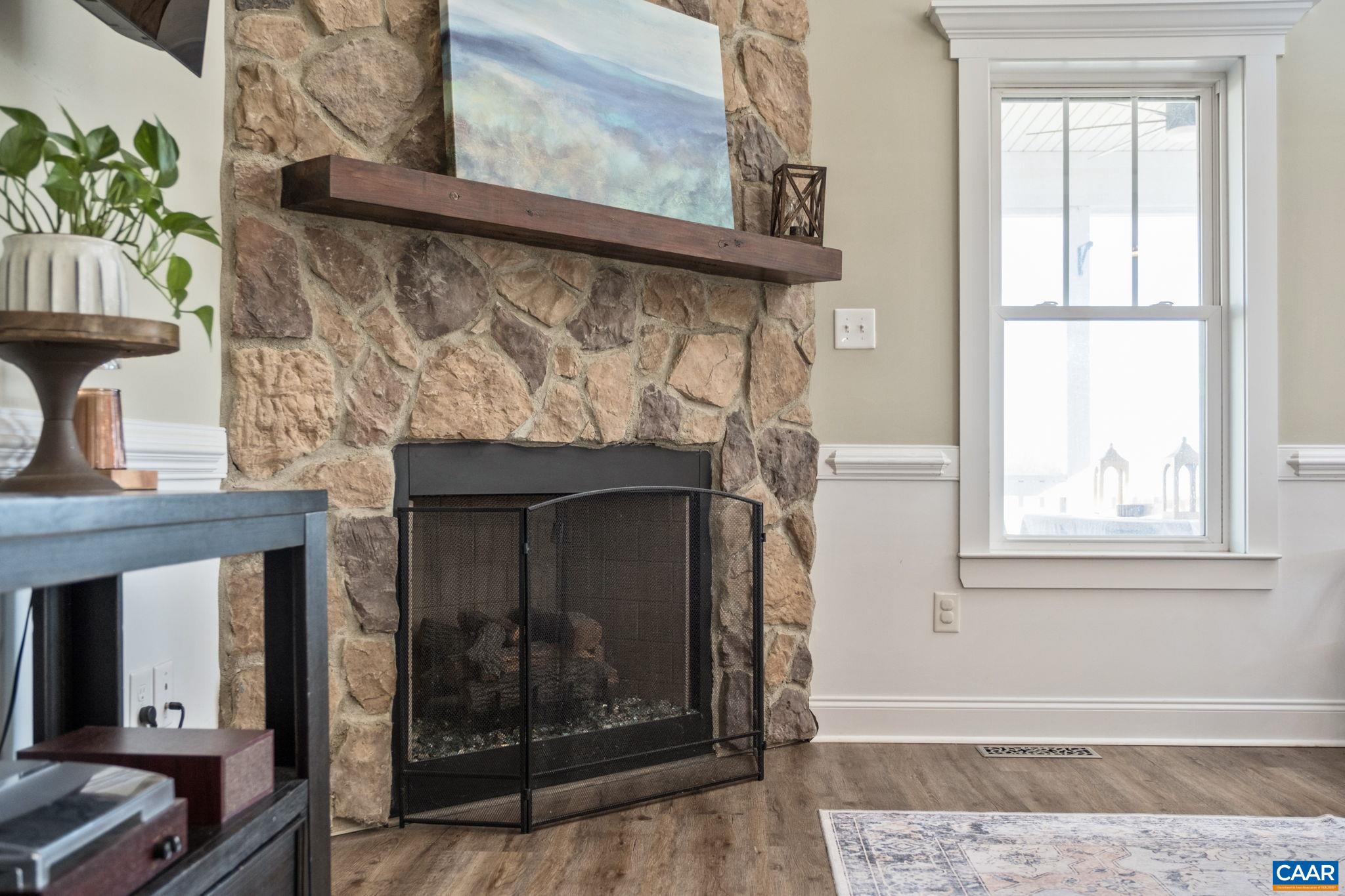 Great room features stone surround, gas log fireplace.