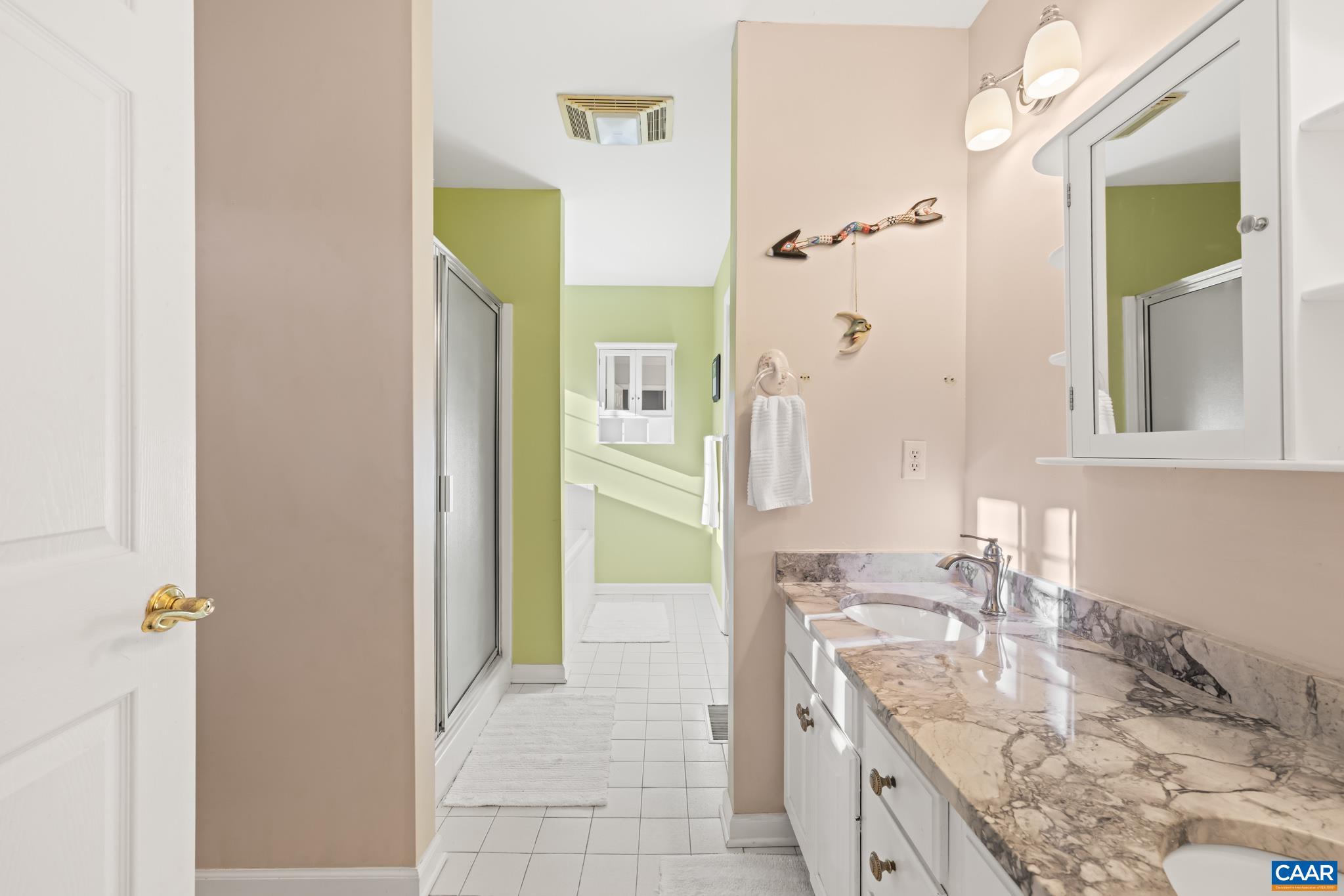 Sun-filled ensuite bath featuring a luxurious jetted soaking tub, separate walk in shower, and dual sink vanity. Bright and airy with excellent natural light, this private retreat offers both comfort and functionality.