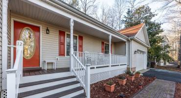 inviting Full Covered front porch capturing serene winter water views of Lake Monticello. Set on a quiet dead end street that is a quick stroll to Beach 2.