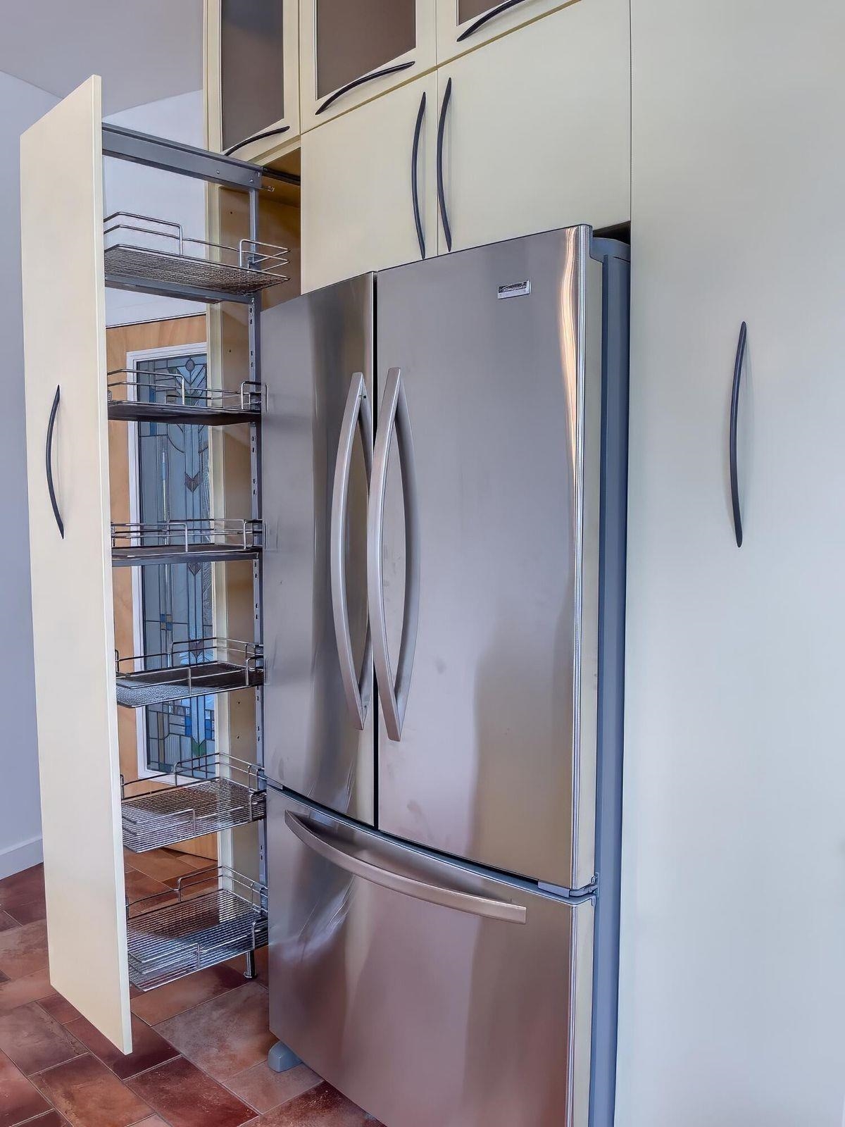 Pull-out spice shelves on either side of the large refrigerator.