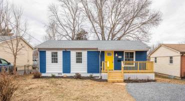 The front view of the single family home, newly renovated, and ready for new owners!  The front view highlights the spacious front deck space, over-sized driveway, updated roof, and large, level, yard area.