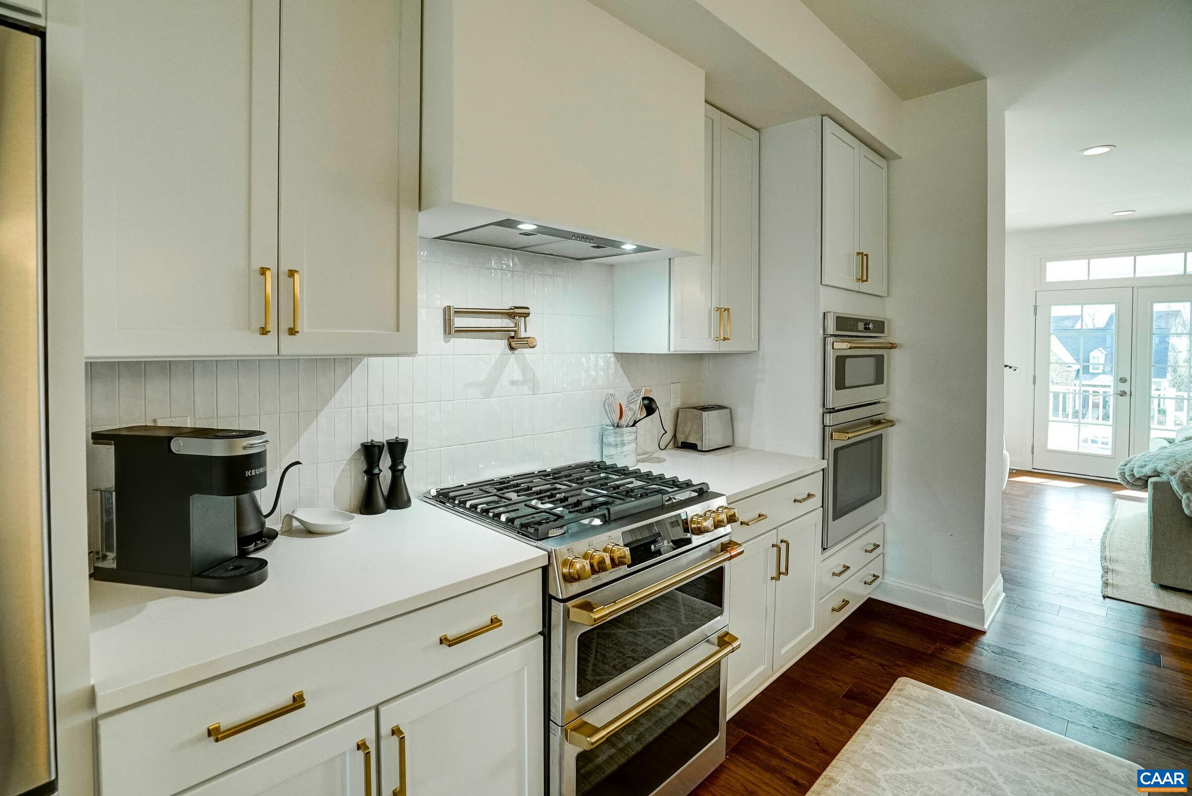 Modern range hood and pot-filler over upgraded gas range.