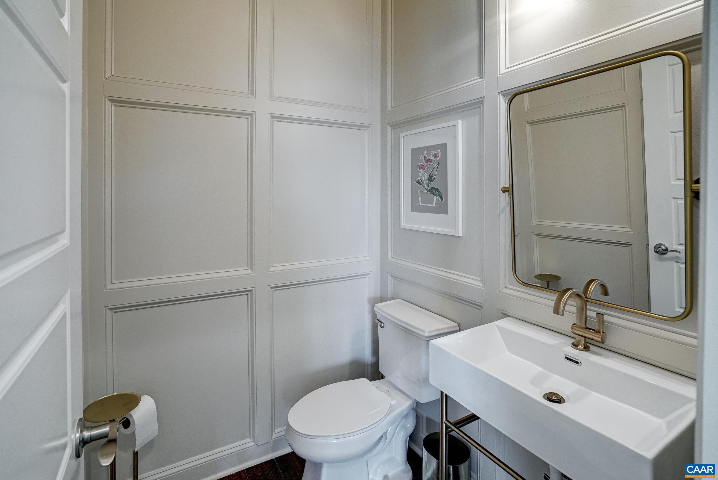 Updated powder room features updated vanity, fixtures, trim details and lighting.