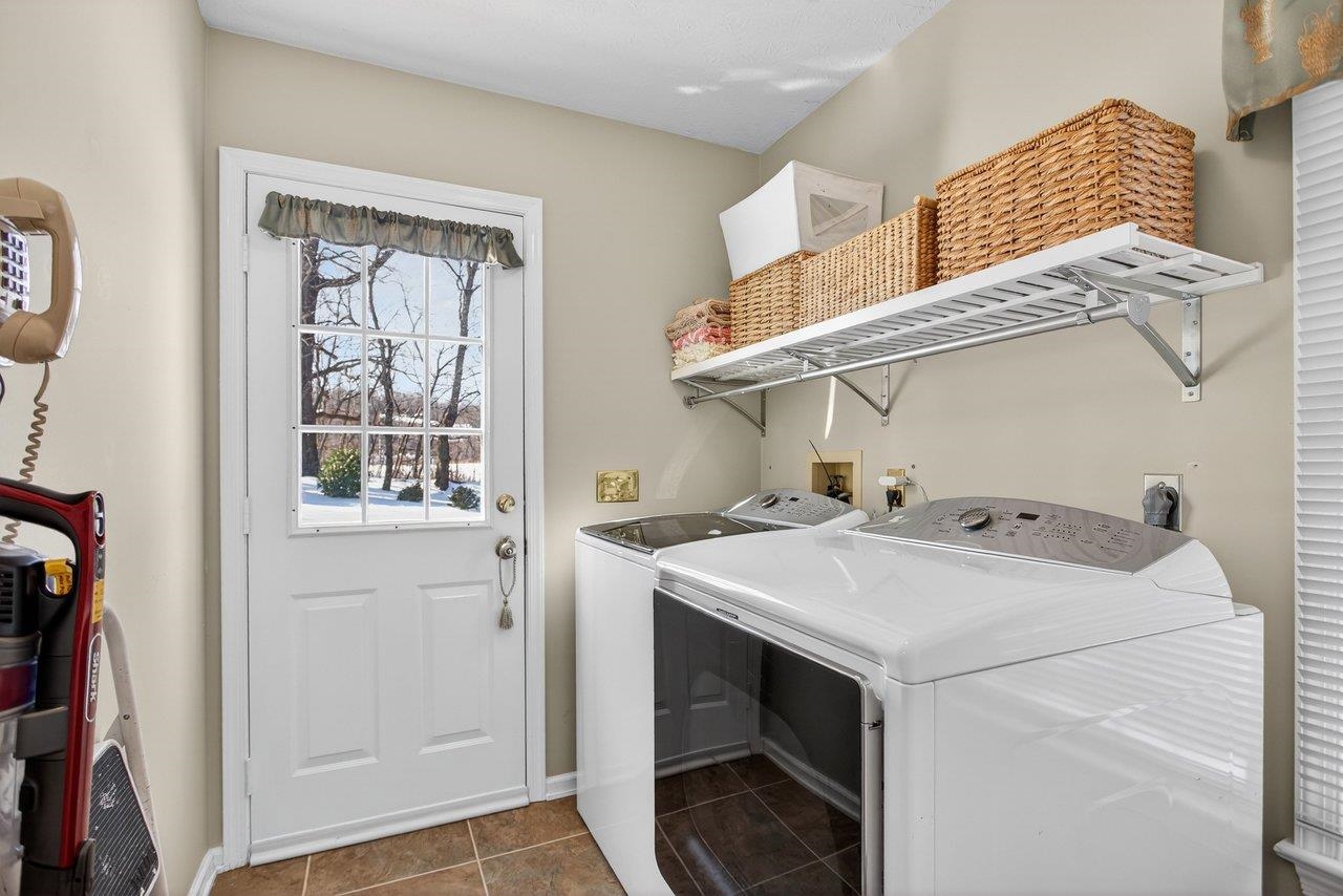 Tile floor, shelving. storage closet and door out to the backyard.