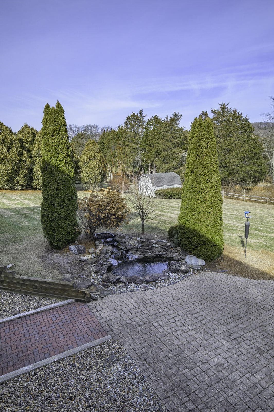 Within the fenced yard is a garden shed, which you can see out beyond the fish pond. Within the fenced yard is a garden shed, which you can see out beyond the fish pond.