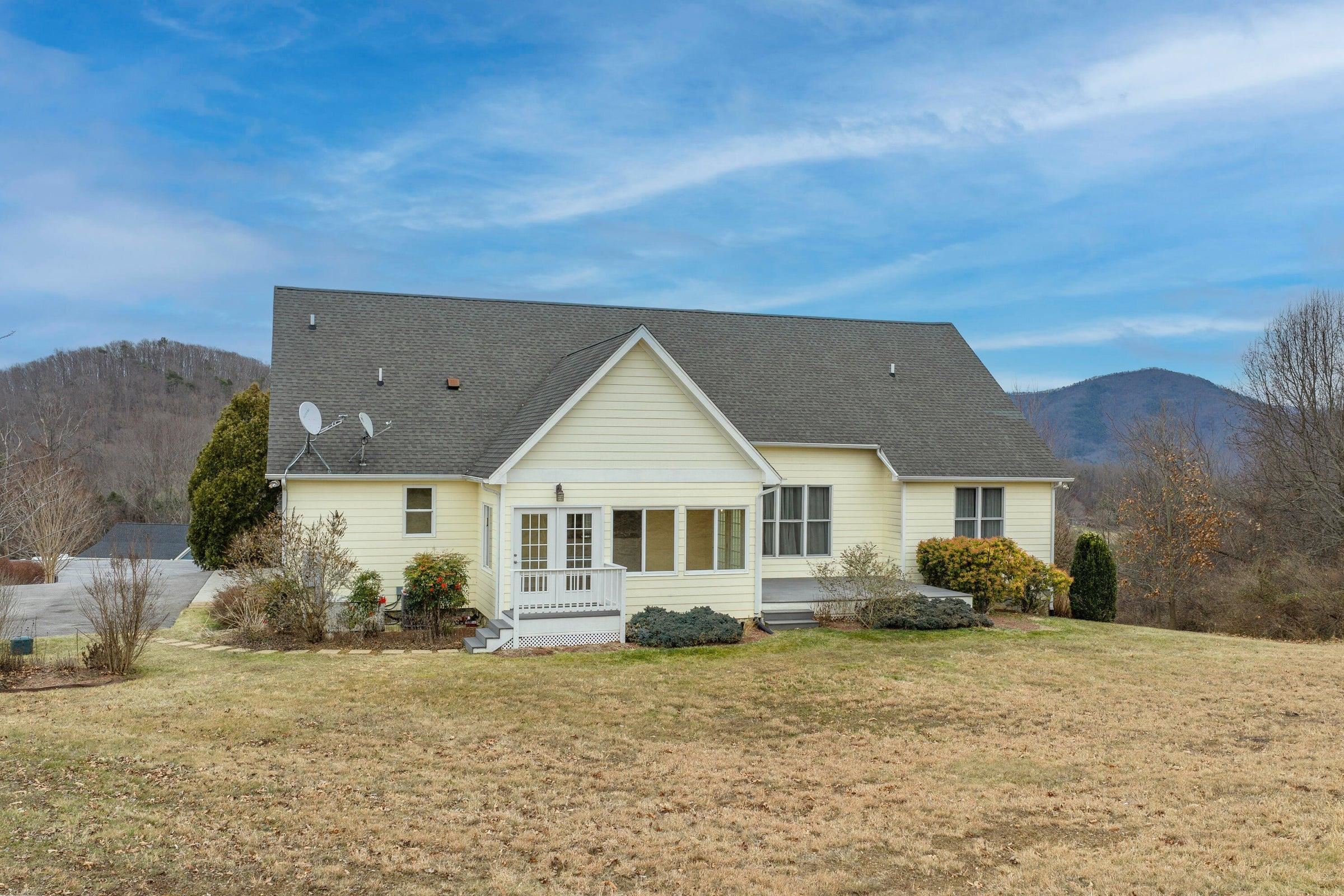 View of the back of the house showing a patio on the right side of the sunroom.