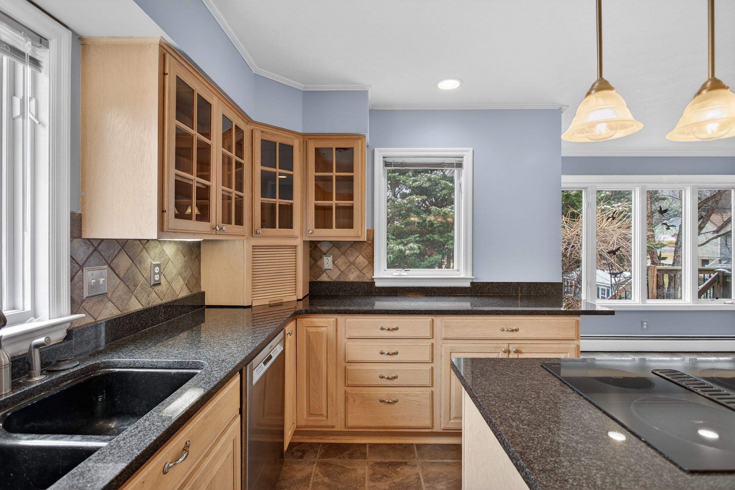 The large kitchen is located near the rear of the home and features ceramic tile flooring, granite counter-tops, wooden cabinetry, recessed lighting, and stainless steel appliances.