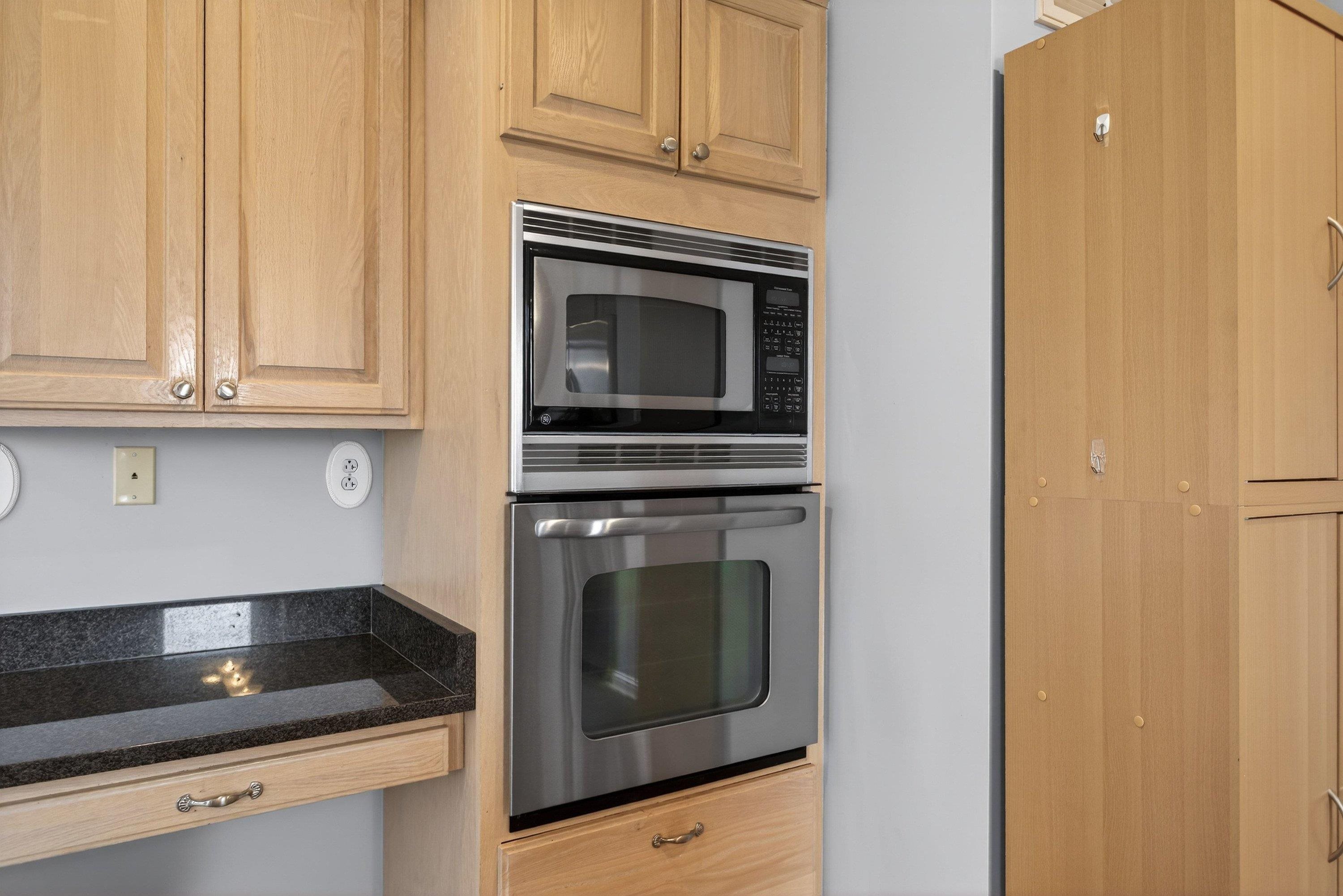 The large kitchen is located near the rear of the home and features ceramic tile flooring, granite counter-tops, wooden cabinetry, recessed lighting, and stainless steel appliances.