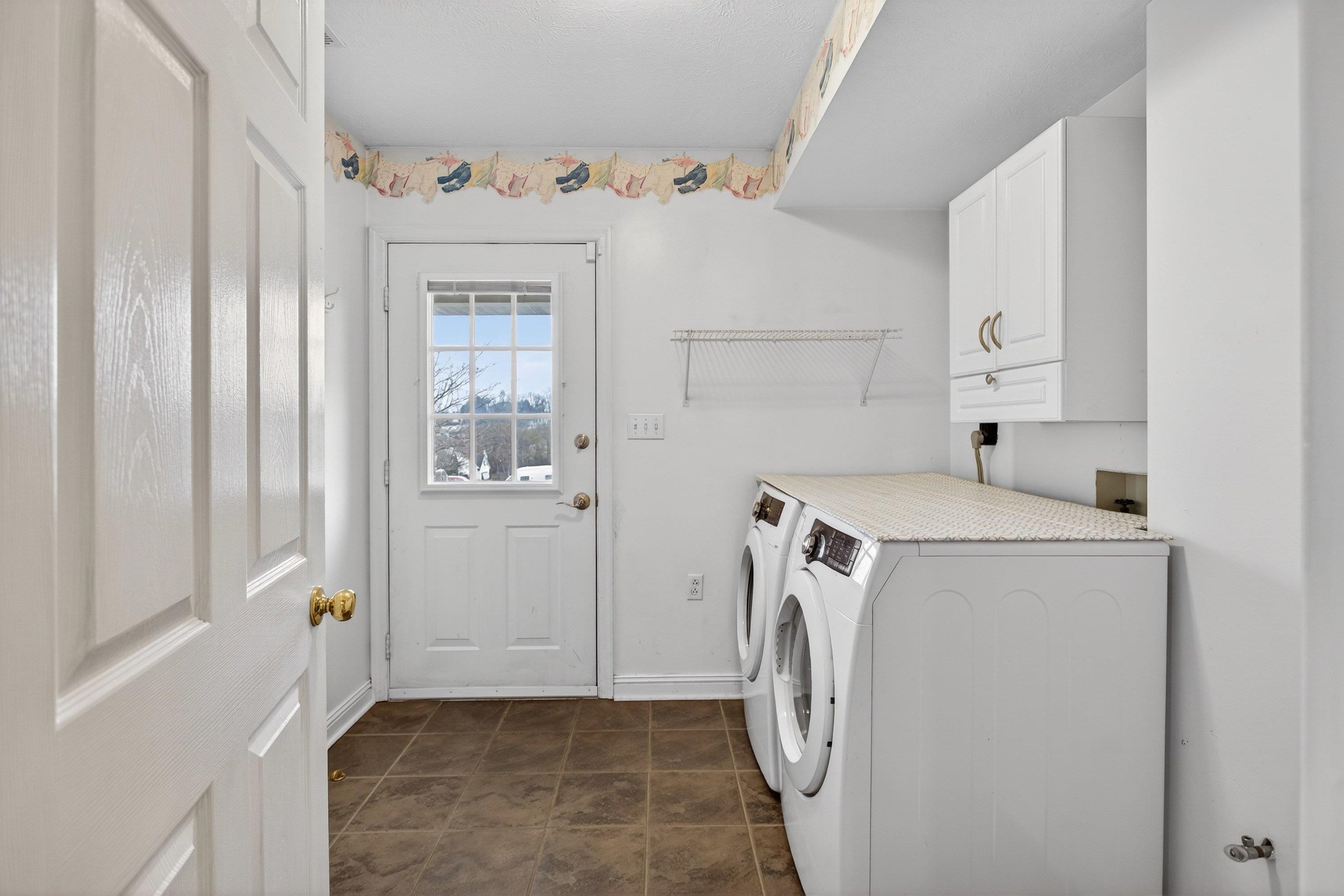 The laundry room is located on the main level of the home.  The laundry space offers full-size hookups for a washer & dryer, cabinetry, and tile flooring.