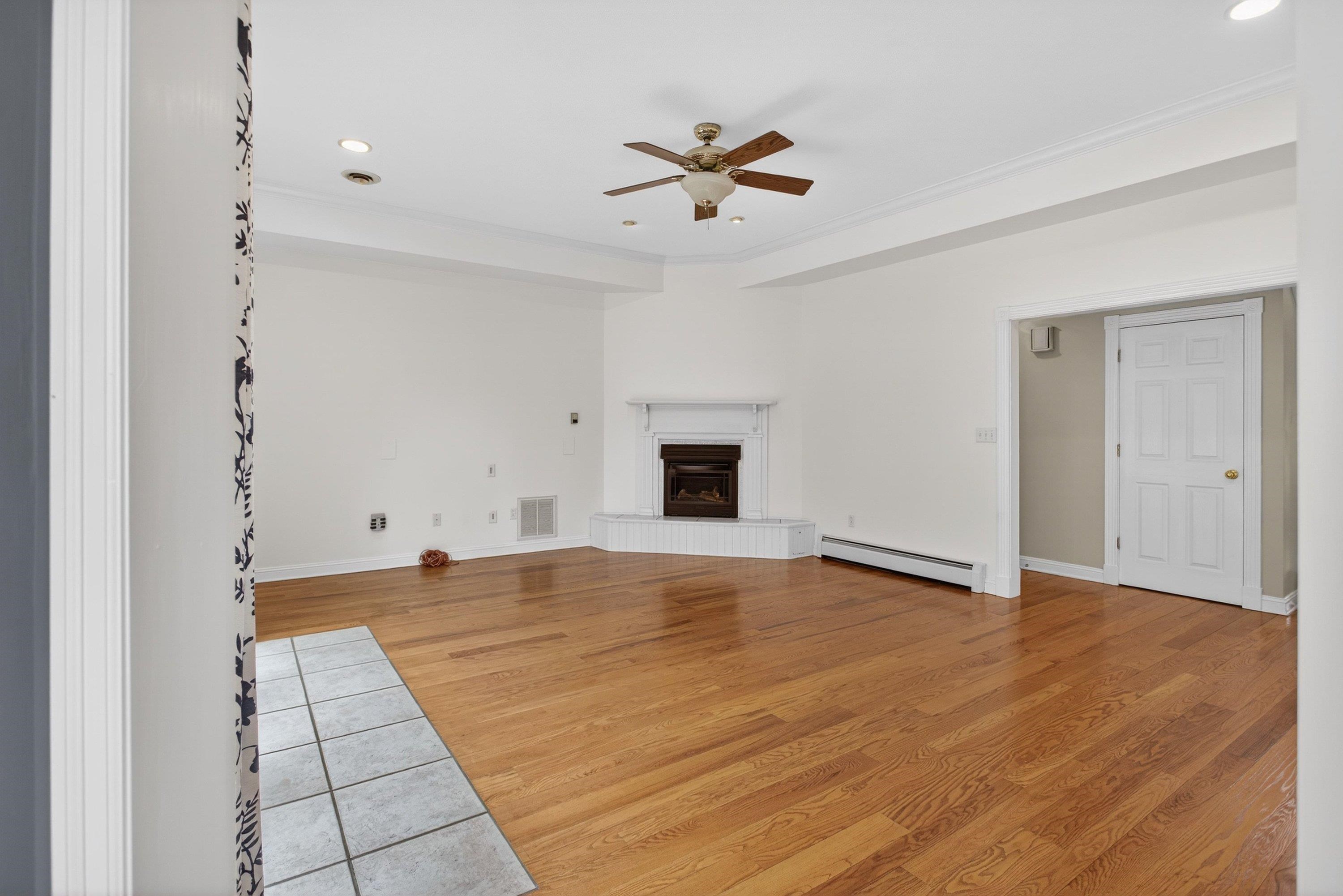 The living room offers a vaulted ceiling and hardwood treads throughout.  This space also features a gas fireplace, ceiling fan, and a large space with a lot of natural light throughout.