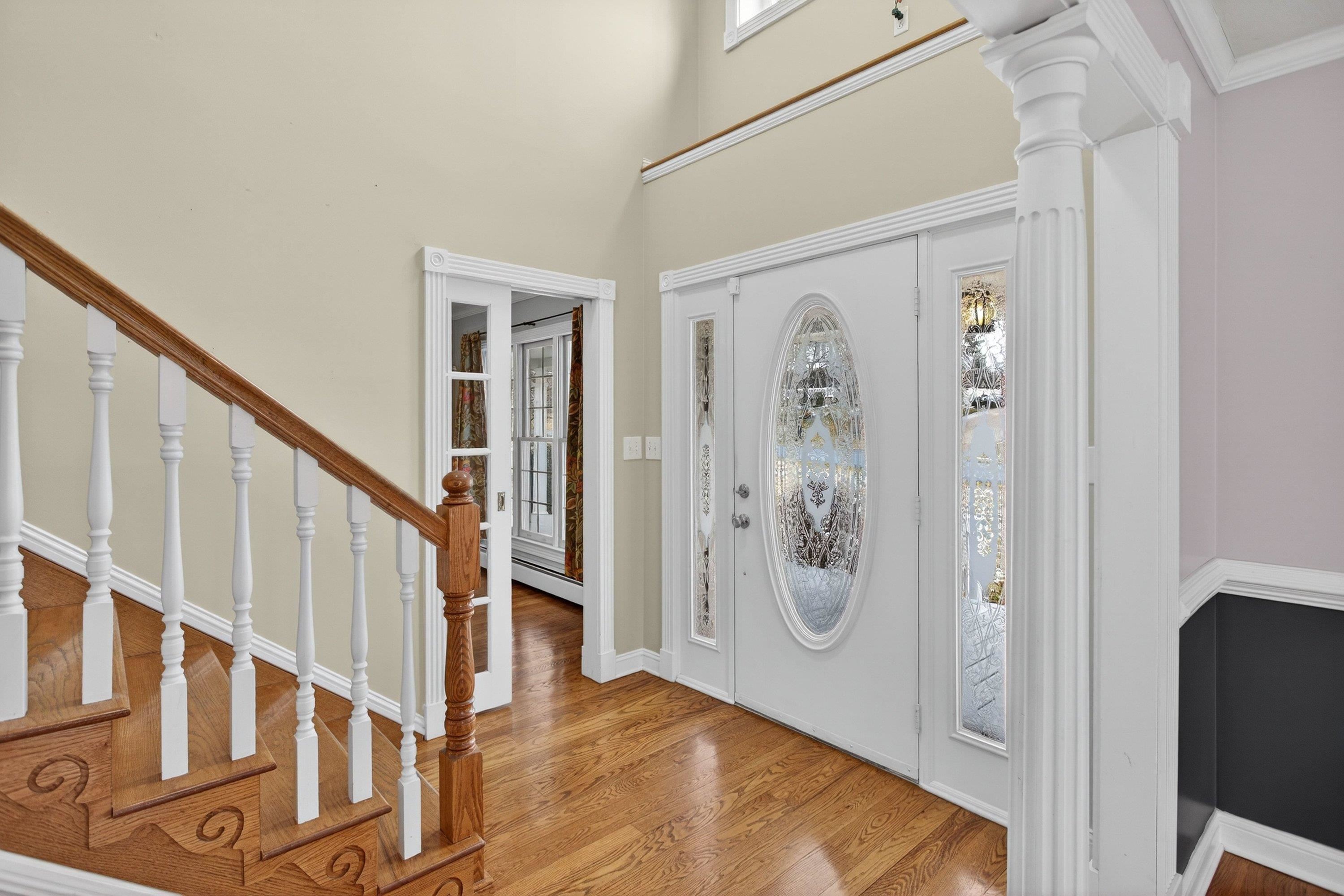 The large foyer space greets you as you enter the home, and features hardwood flooring, decorative windows, and hardwood treads leading to the upper level of the home.