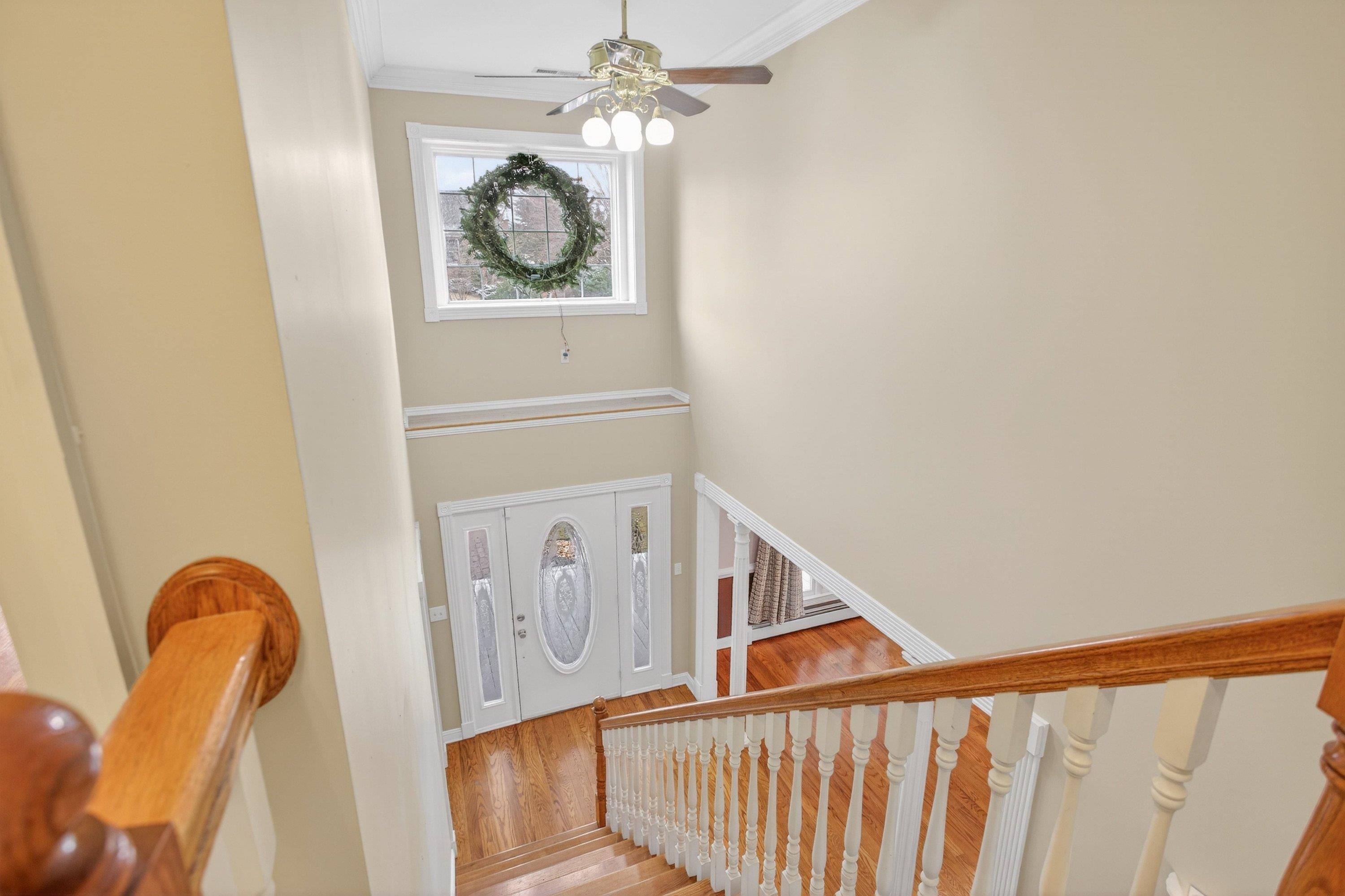 The large foyer space greets you as you enter the home, and features hardwood flooring, decorative windows, and hardwood treads leading to the upper level of the home.