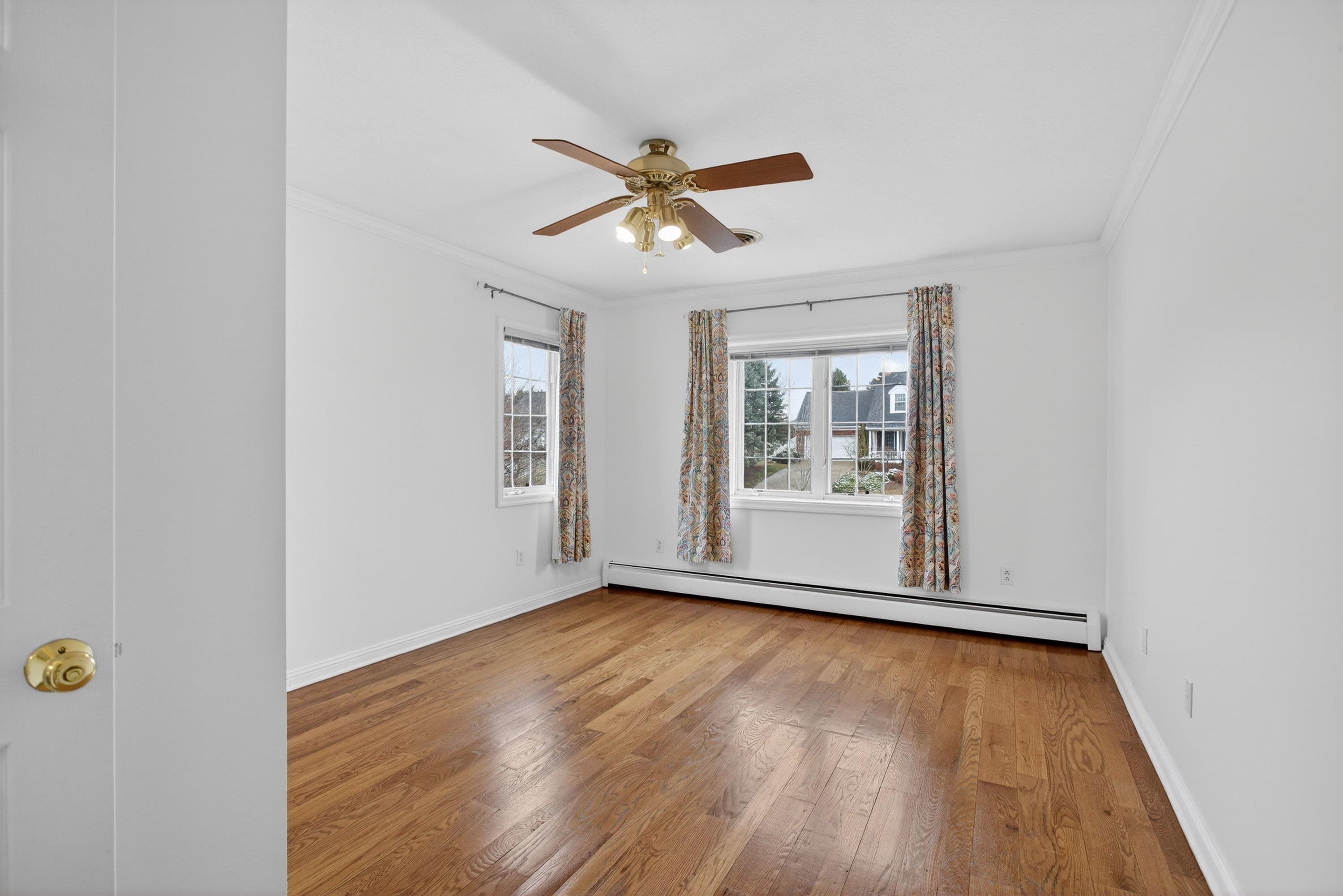 This second bedroom offers hardwood flooring throughout, ceiling fan, large windows, and a full attached bathroom.