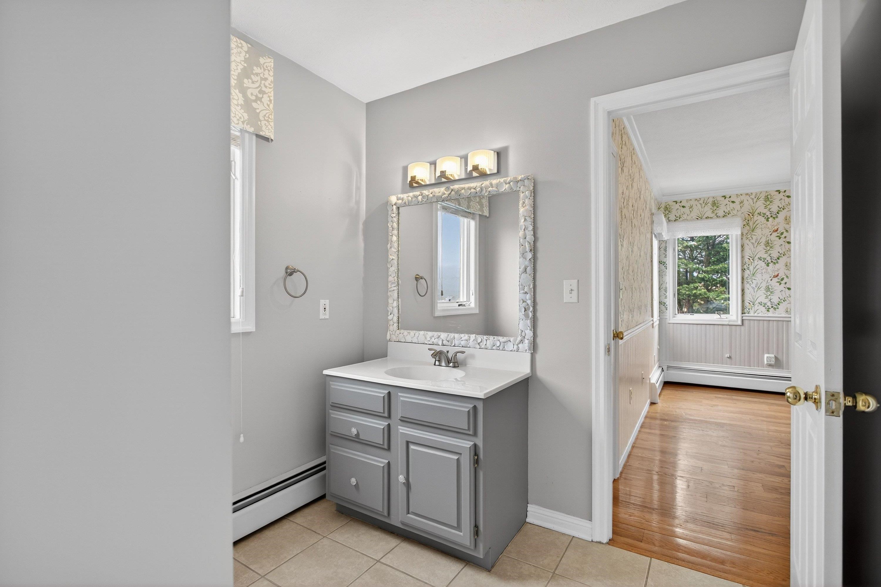 This full bathroom offers convenience to bedrooms 3 and 4 and has a vanity with storage and a seperate room with the toilet/shower space.