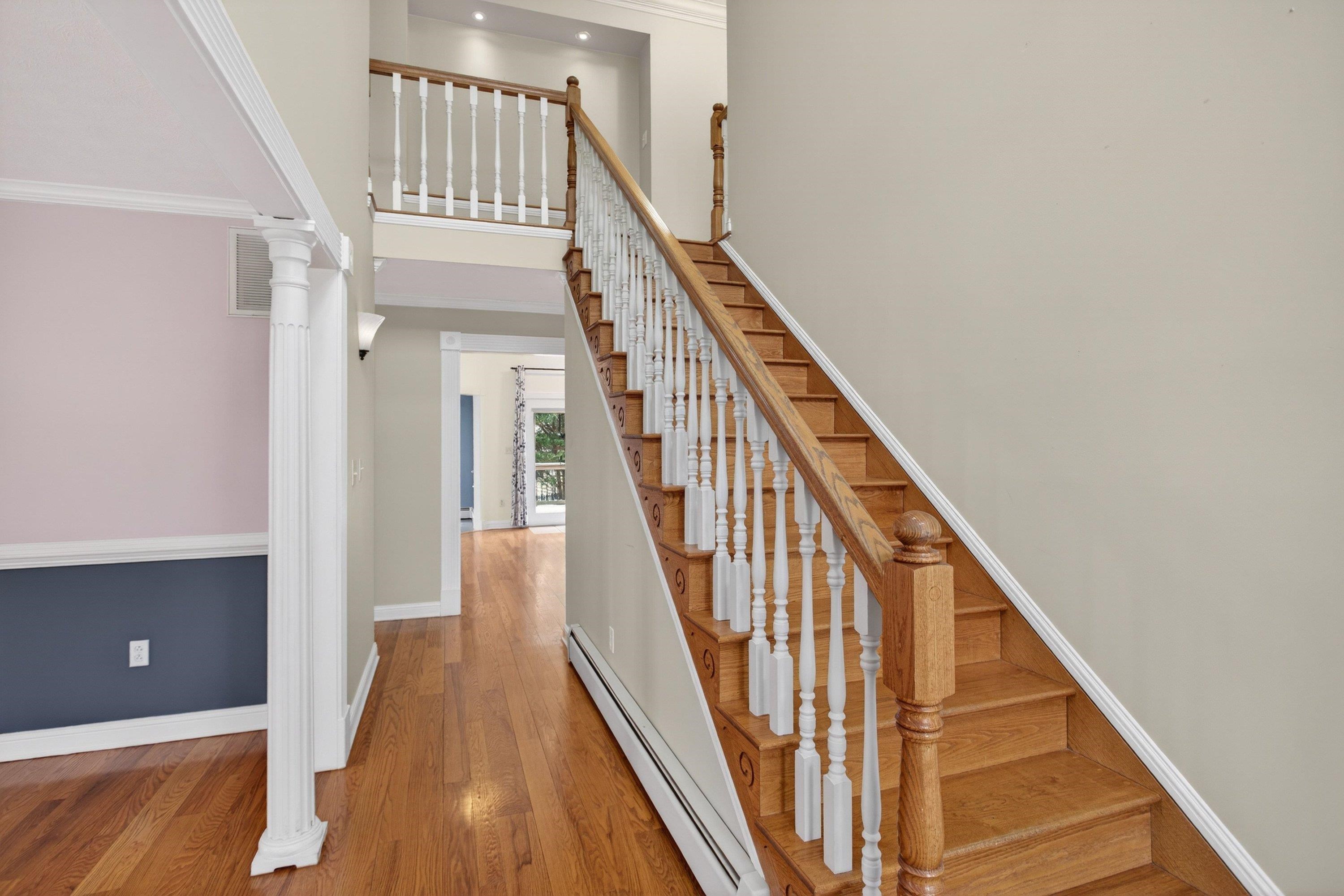 The large foyer space greets you as you enter the home, and features hardwood flooring, decorative windows, and hardwood treads leading to the upper level of the home.