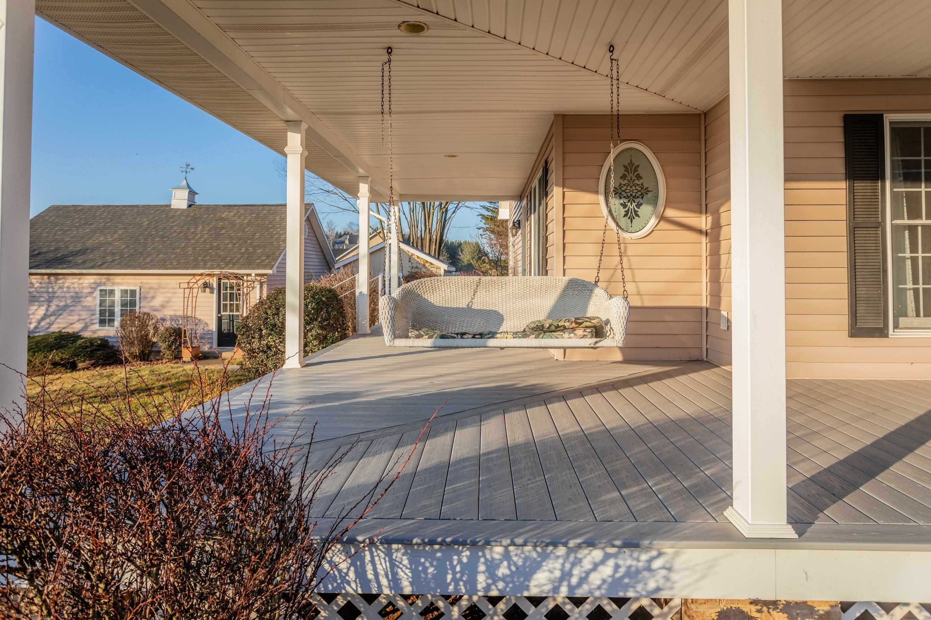 The front porch is very large and wraps around the front and sides of the home.  This porch offers composite deck flooring boards, and offers plenty of space for sitting and gathering with family and friends.